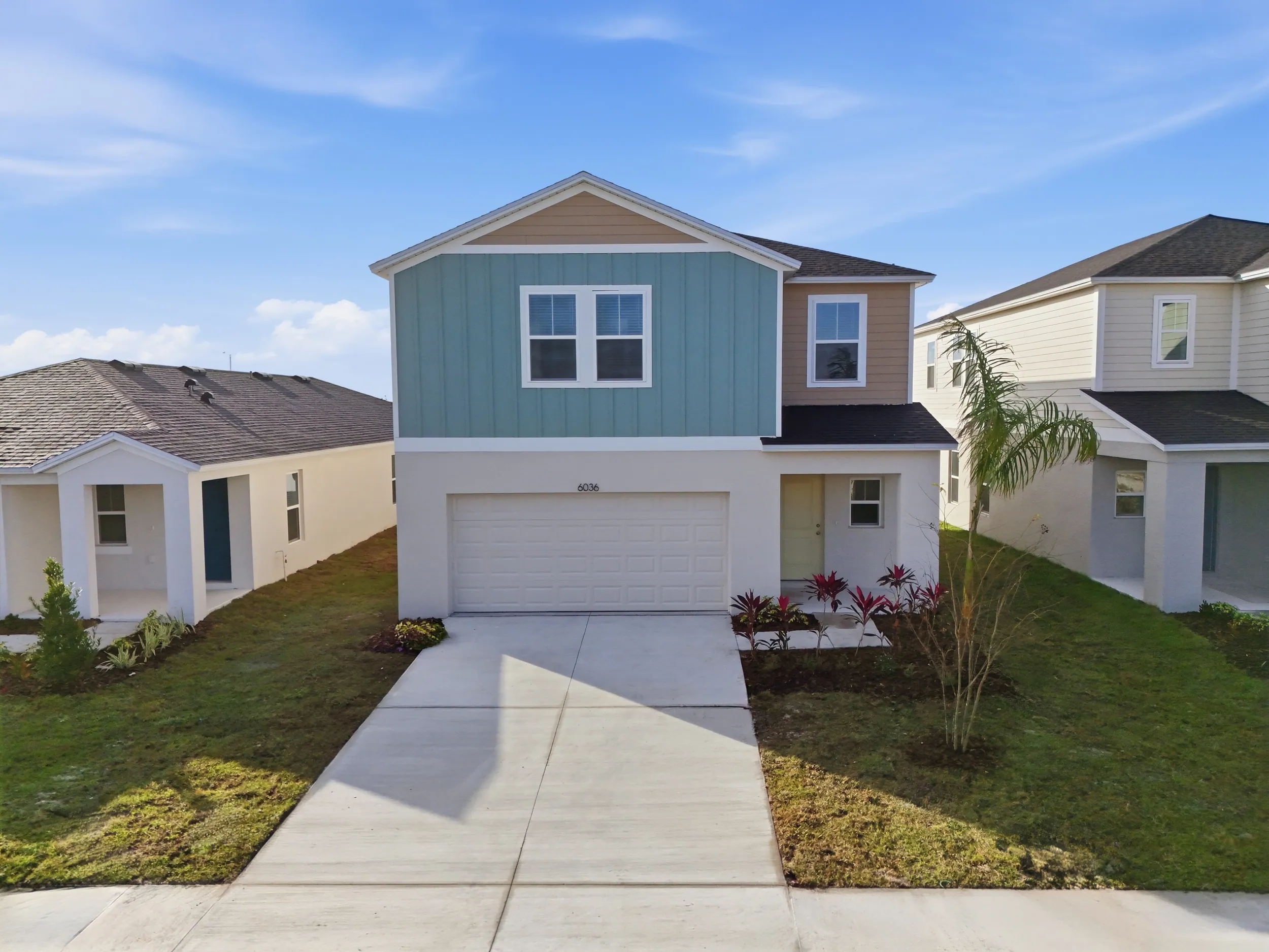 Two-story Villa Mar model with teal siding and a palm