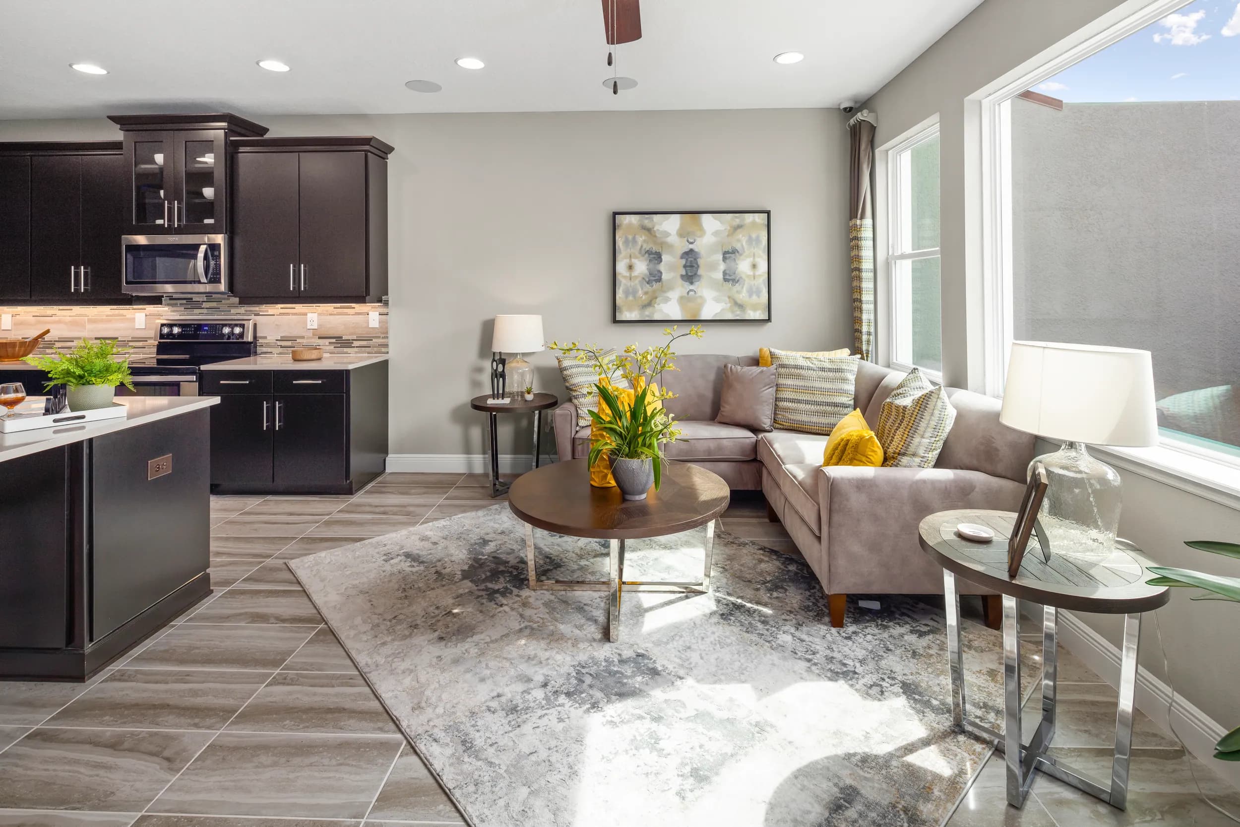 Hawksmoor model family room with dark kitchen and sectional