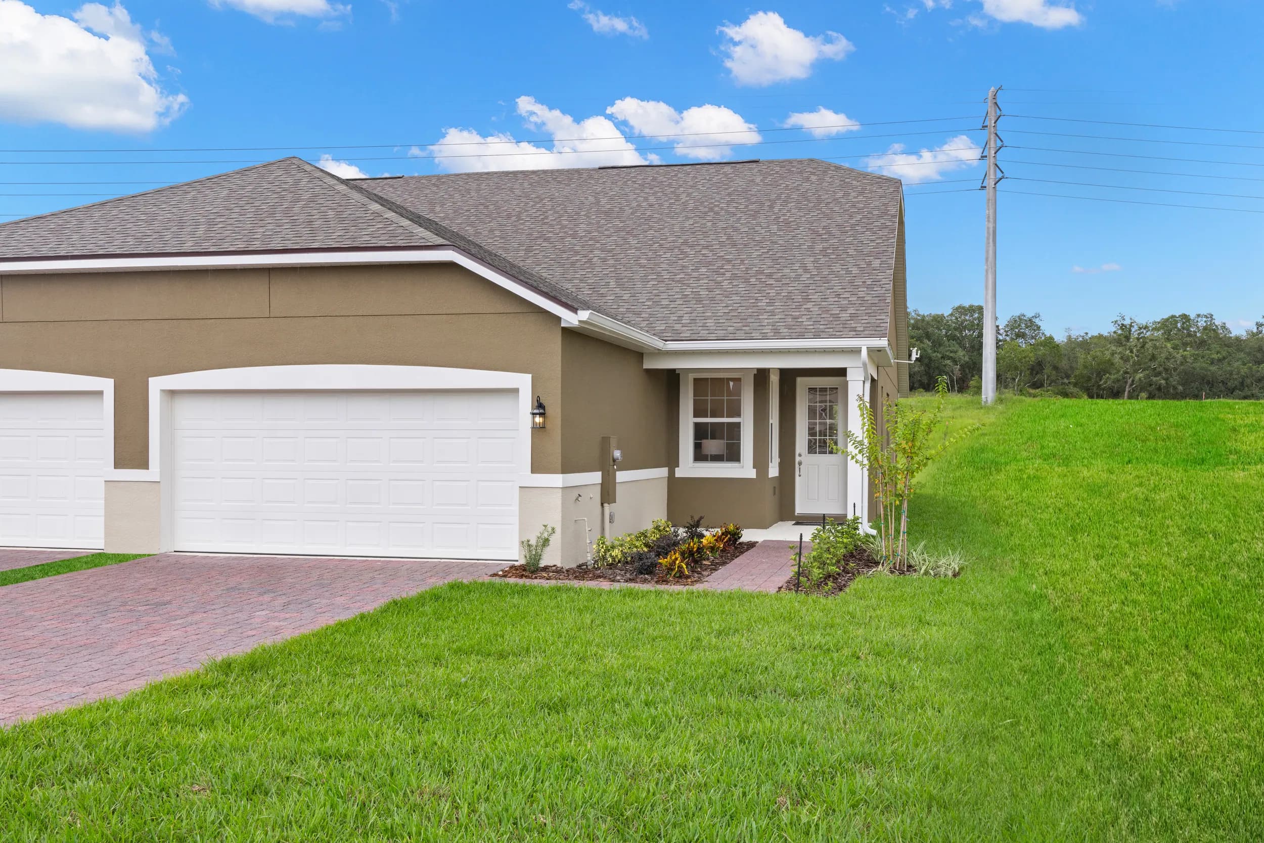 Mattamy villa exterior with brick drive and lawn