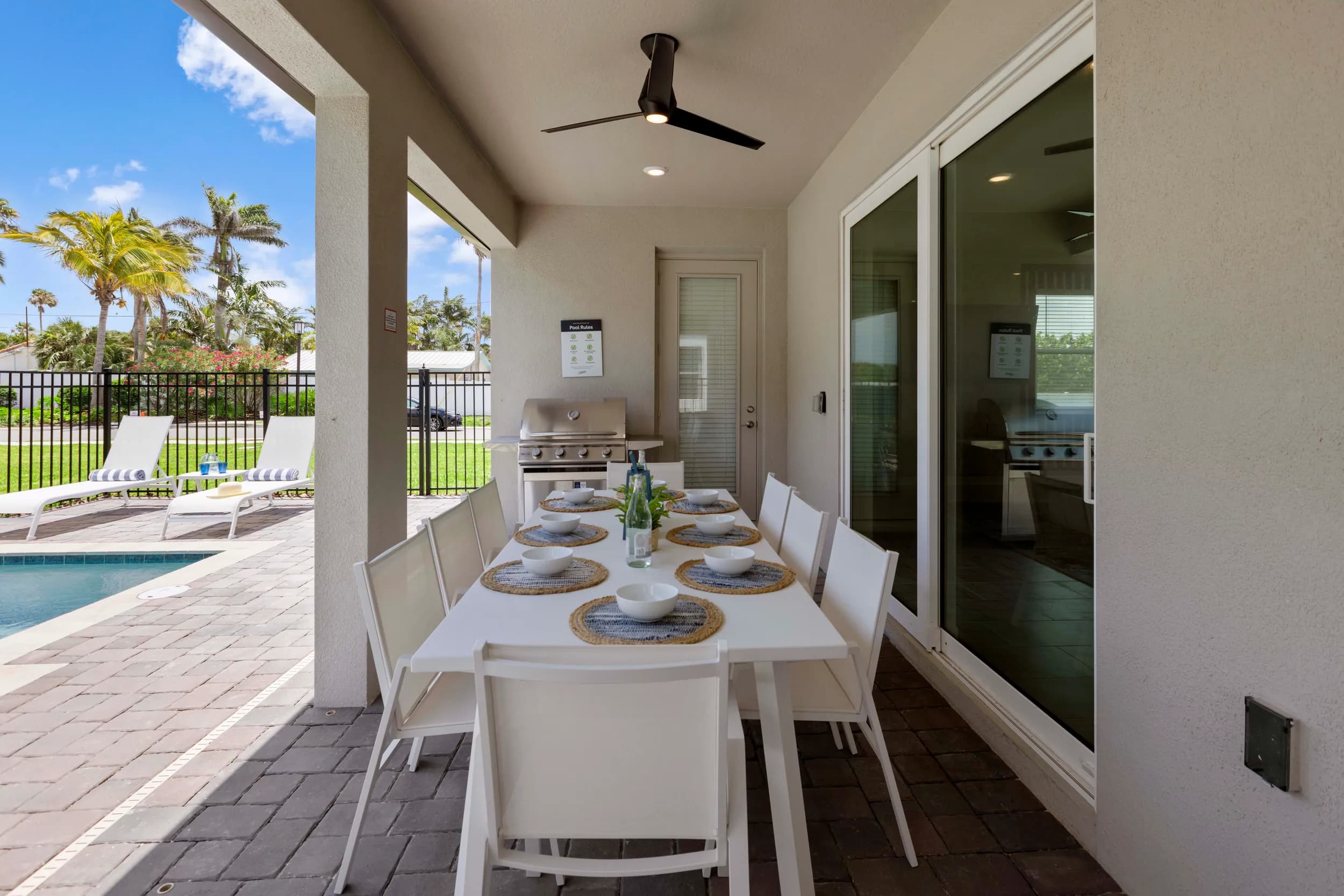 Covered lanai with outdoor dining beside the pool