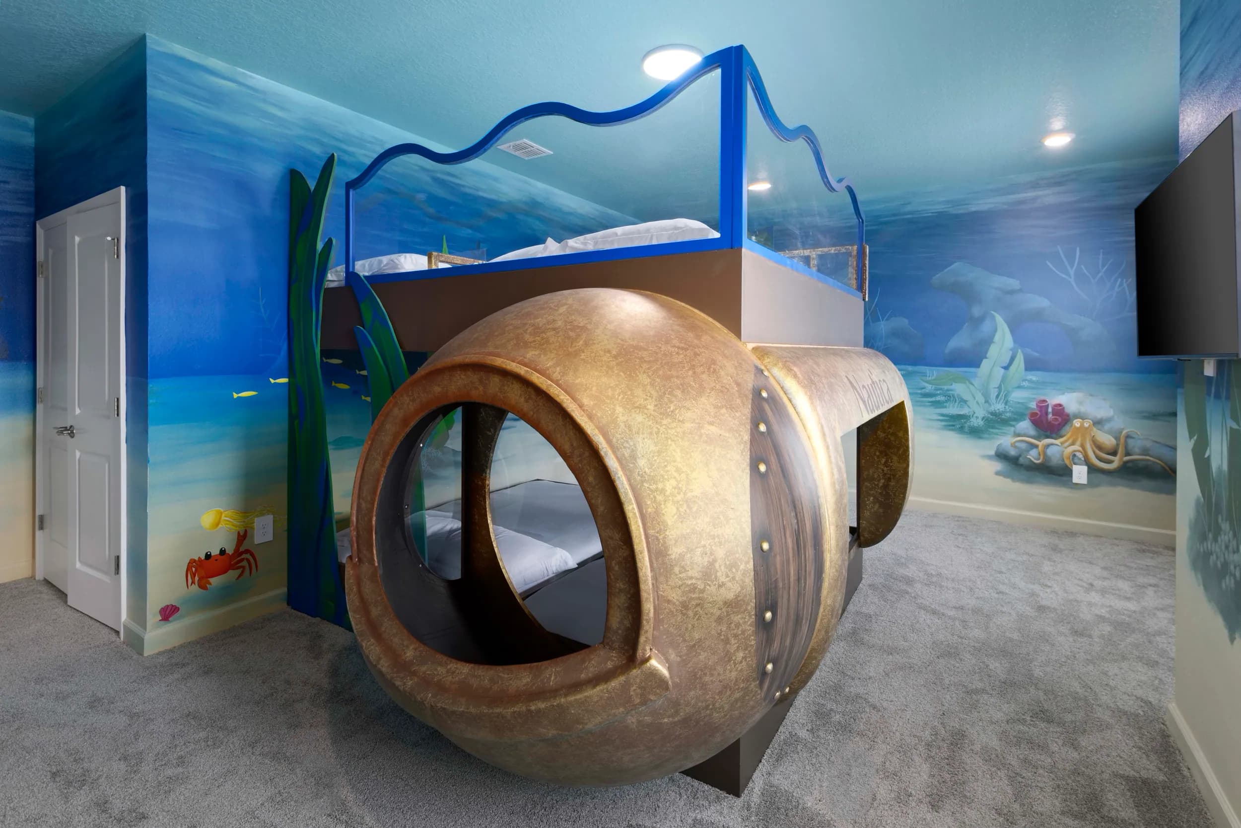 Themed kids bedroom with a submarine bed and underwater mural