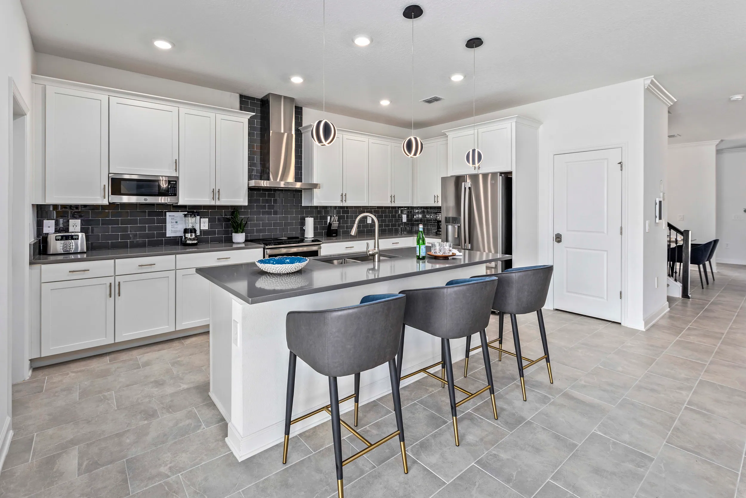 White kitchen with dark backsplash and island seating