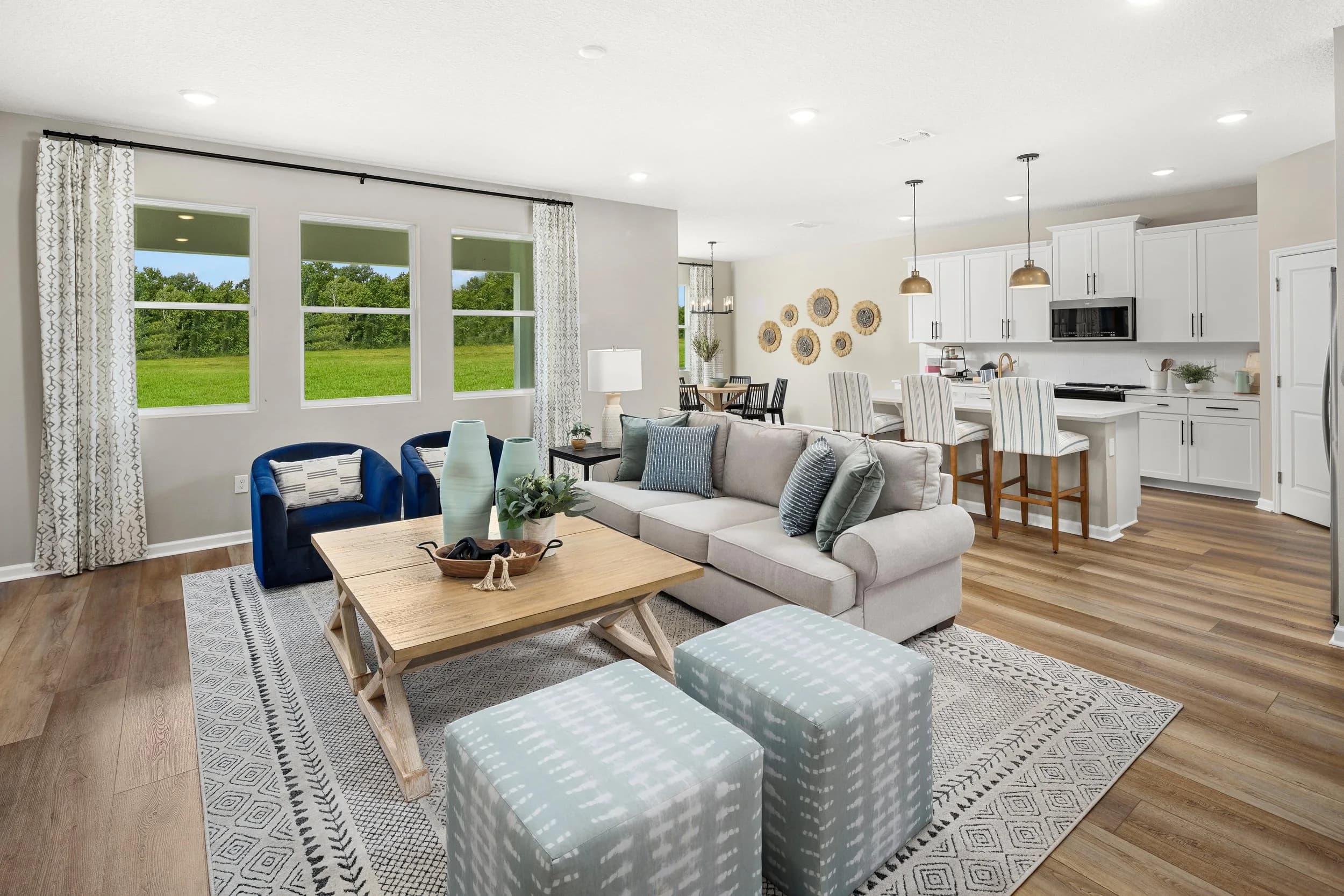 Staged model living room with navy accents and light wood floors