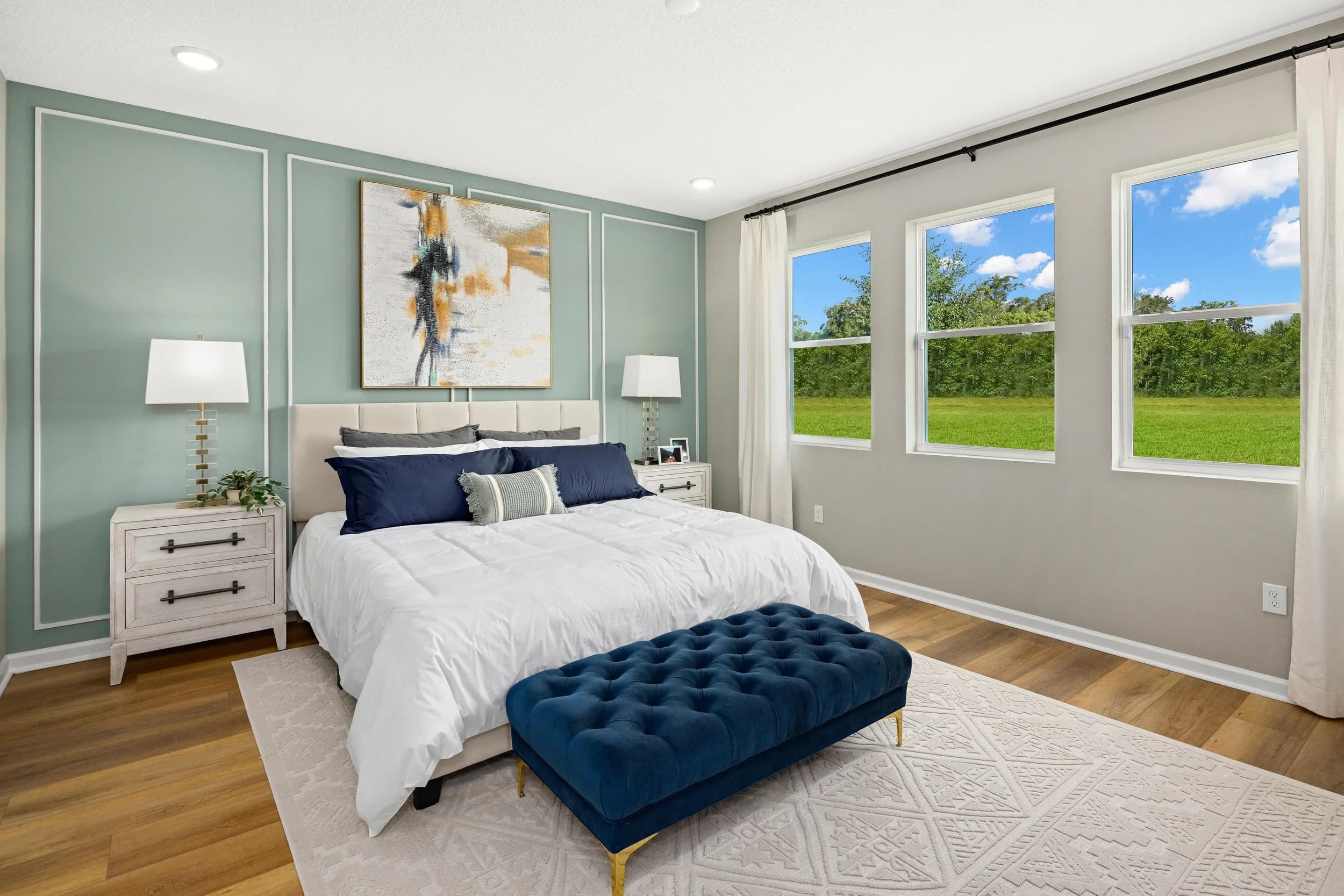 Model bedroom with sage green walls and navy bench