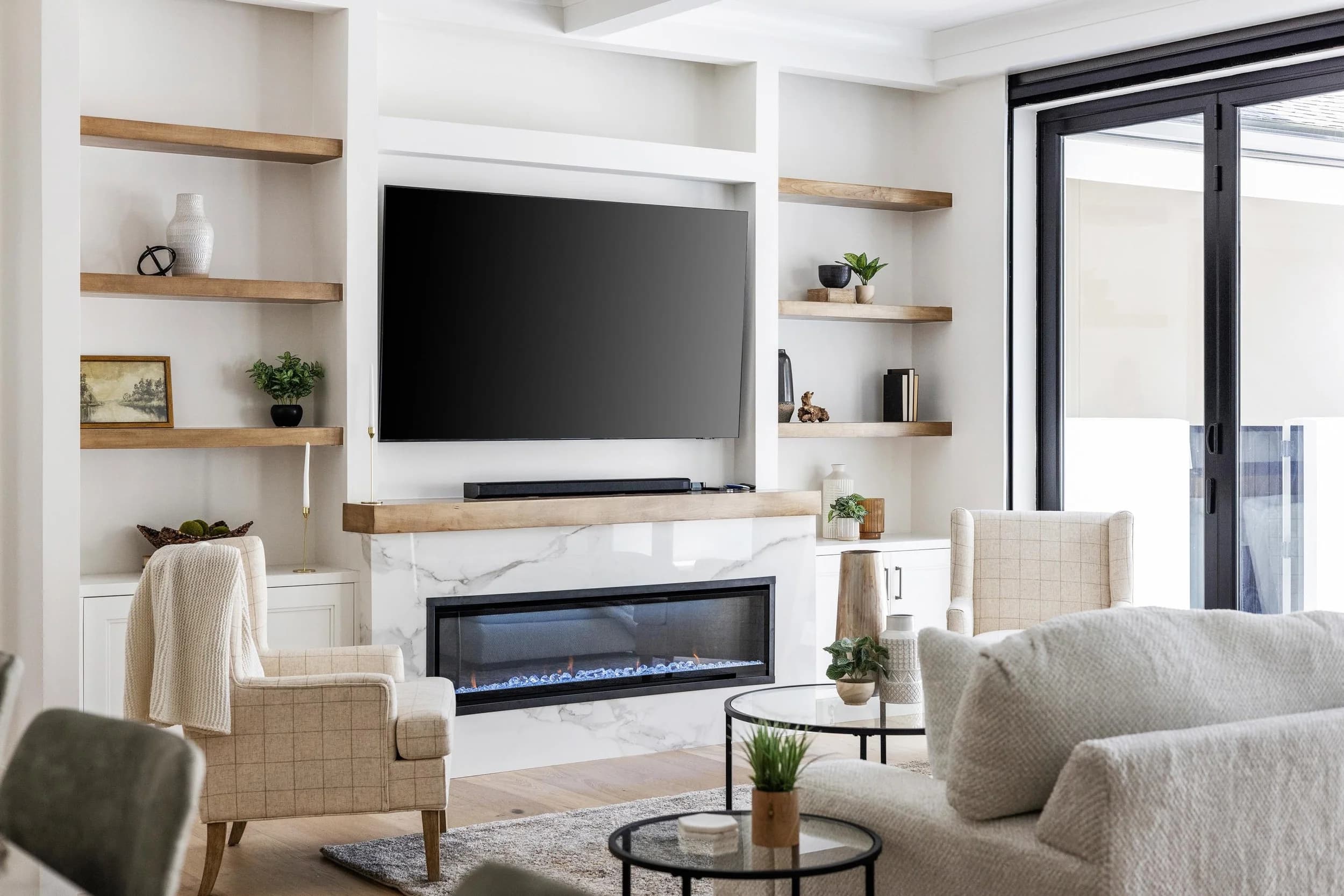Living room with fireplace, built-in shelves, and glass doors