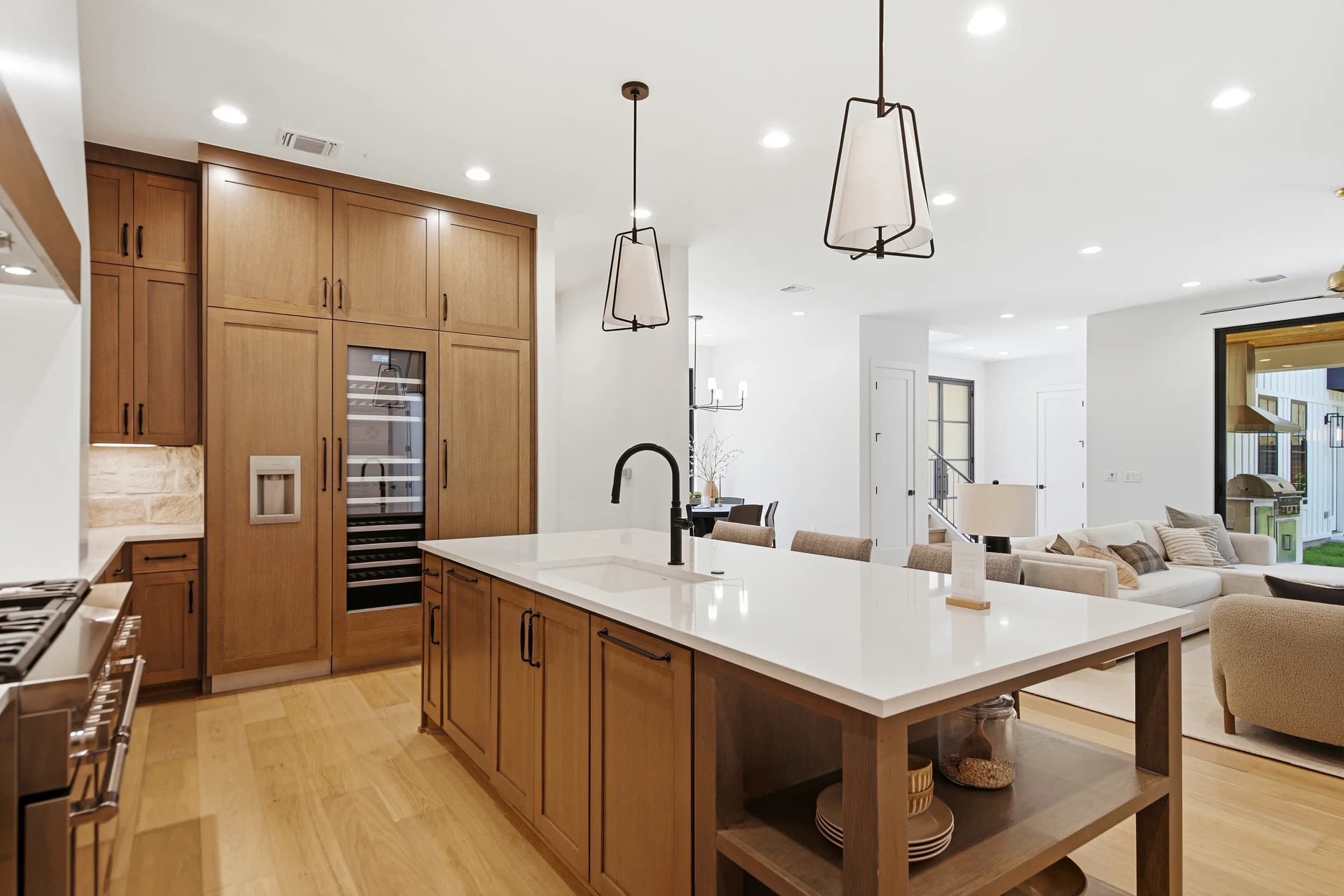 Kitchen with walnut cabinetry, a built-in wine fridge and a waterfall island