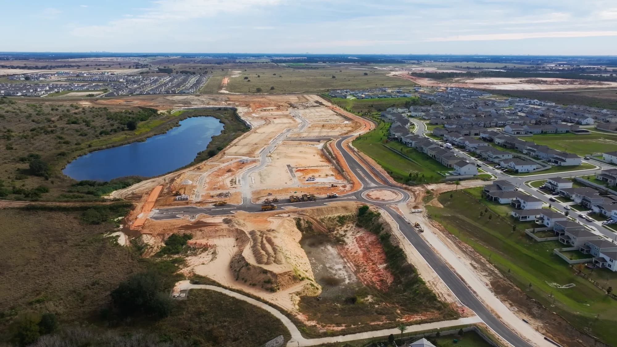 Aerial of a new community with the roundabout and streets complete and lots ready to build
