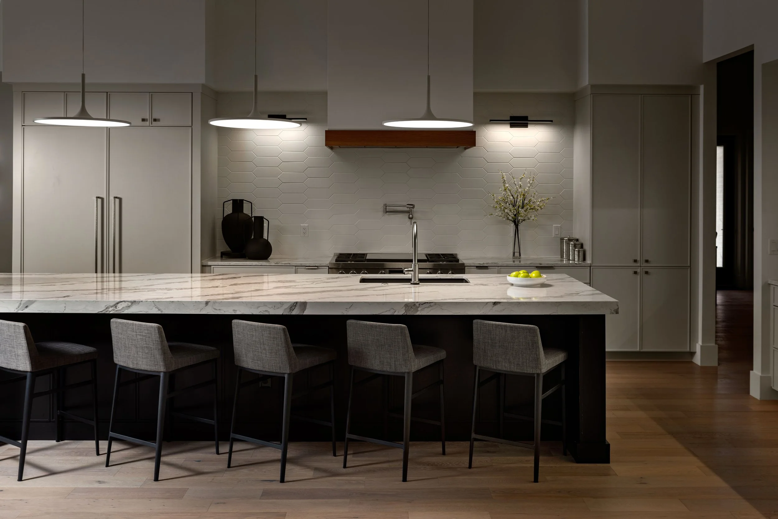Kitchen with marble island and dark pendants