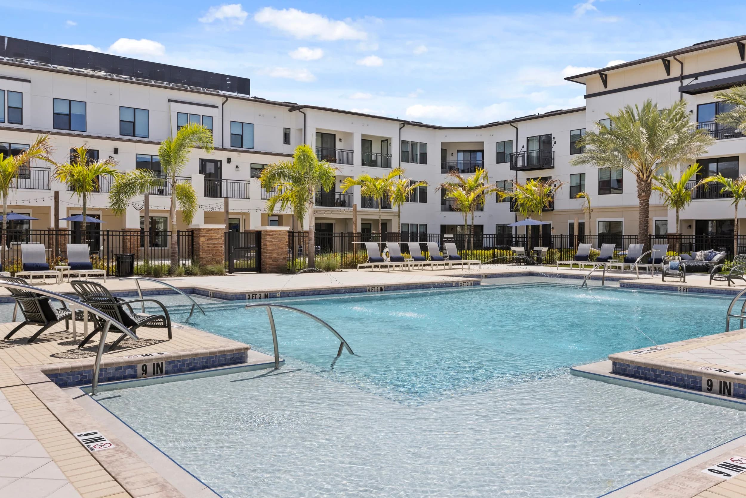 Resort-style apartment community pool with lounge chairs
