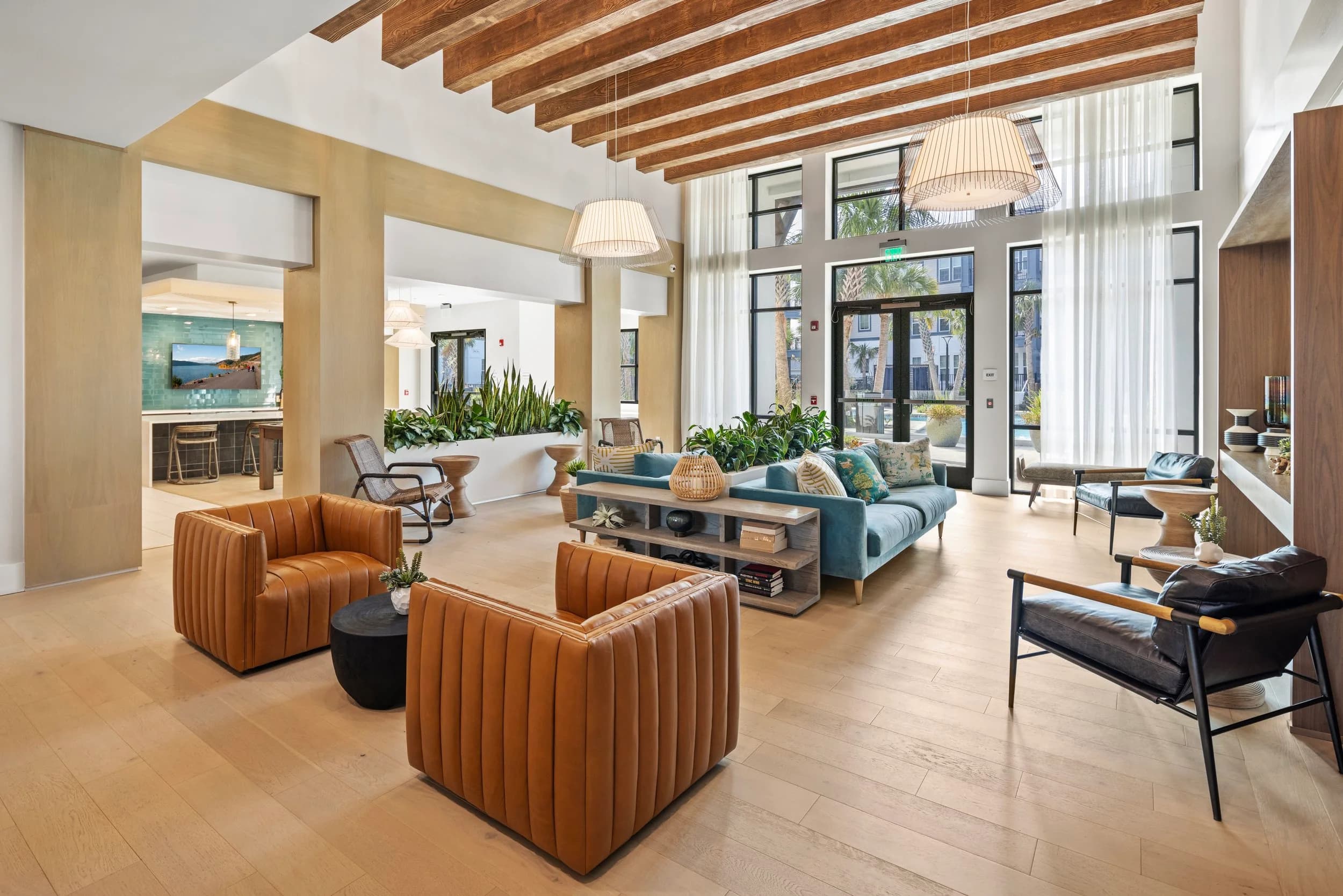 Clubhouse lounge with leather chairs and two-story windows