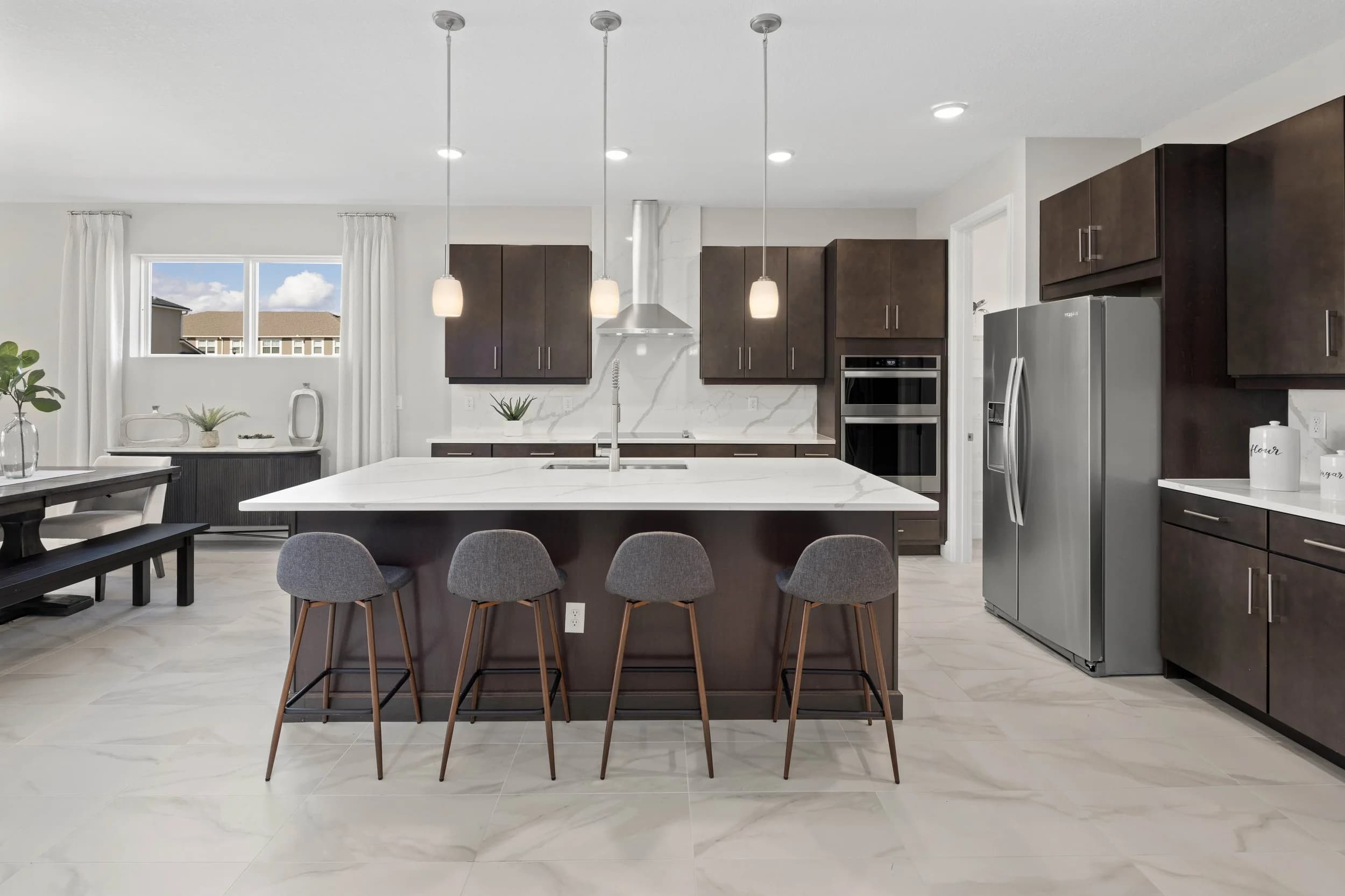 Dark modern kitchen with island seating and three pendants