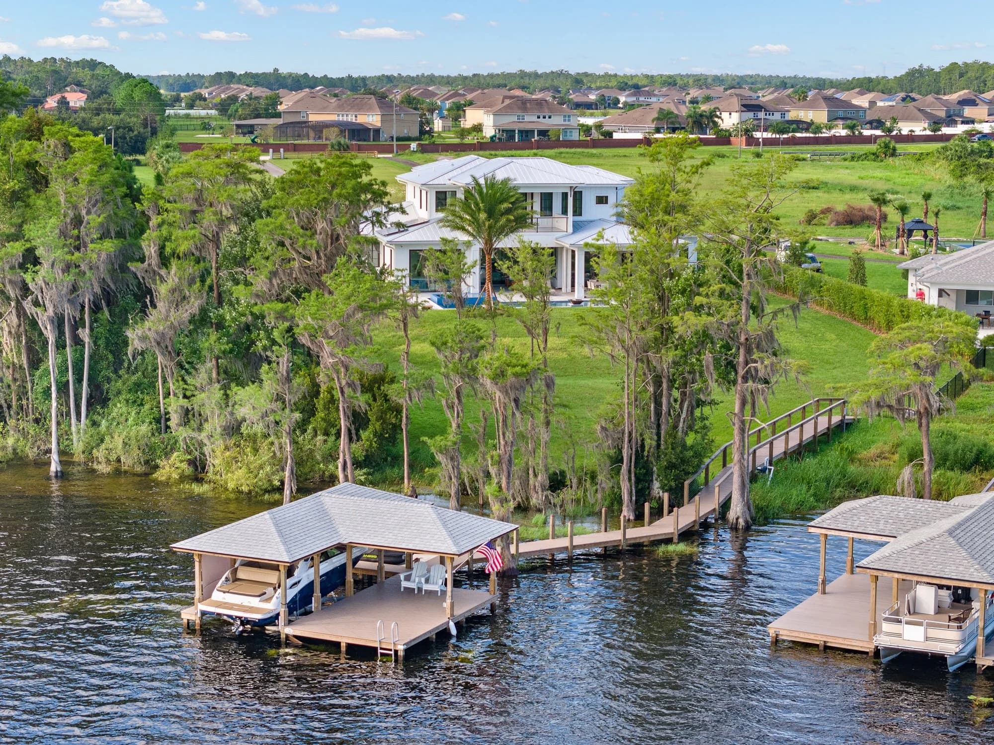 Aerial approach over a lakefront home with dock