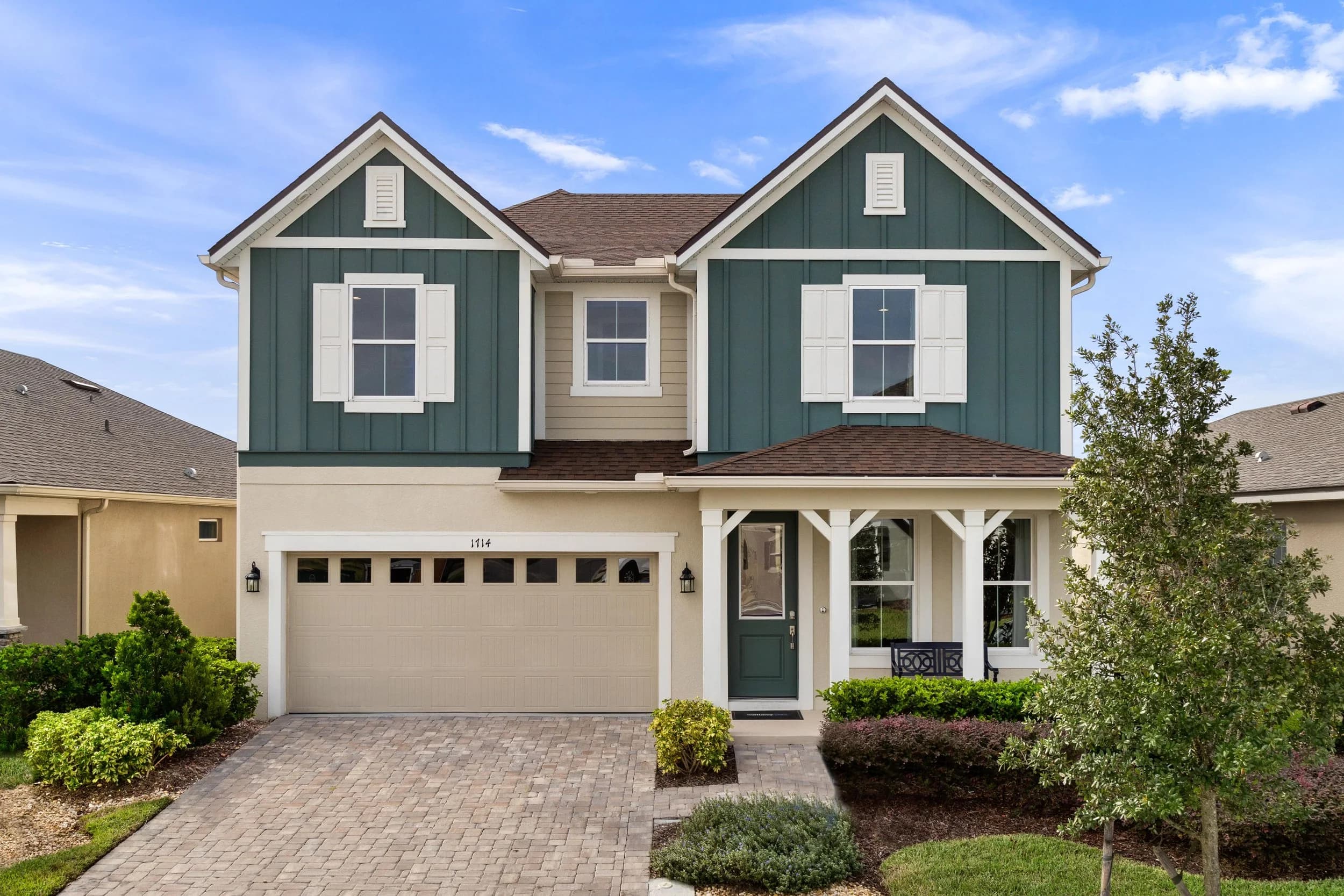 Two-story teal and white model home elevation