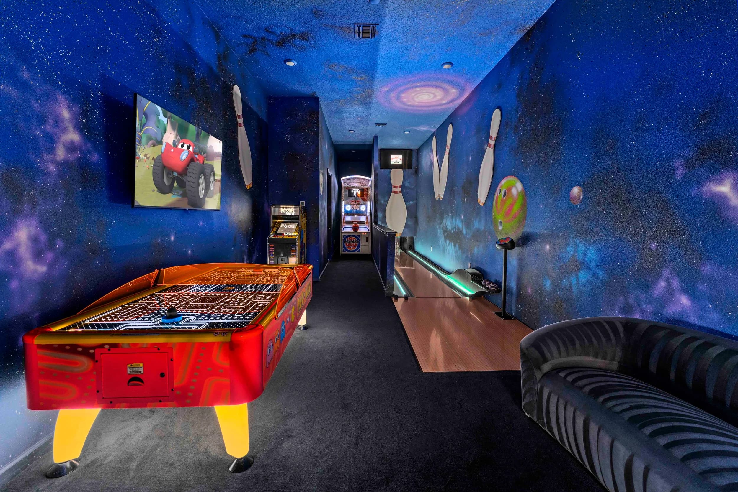 Space-themed game room with arcade and bowling lane