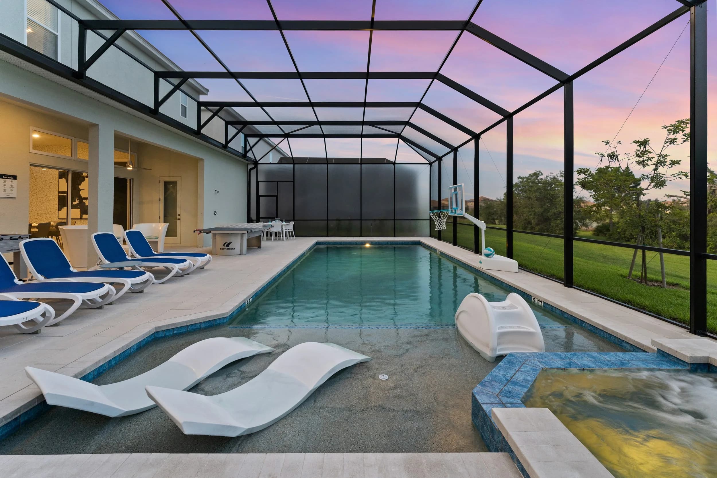 Screened pool and spa at twilight with lounge chairs