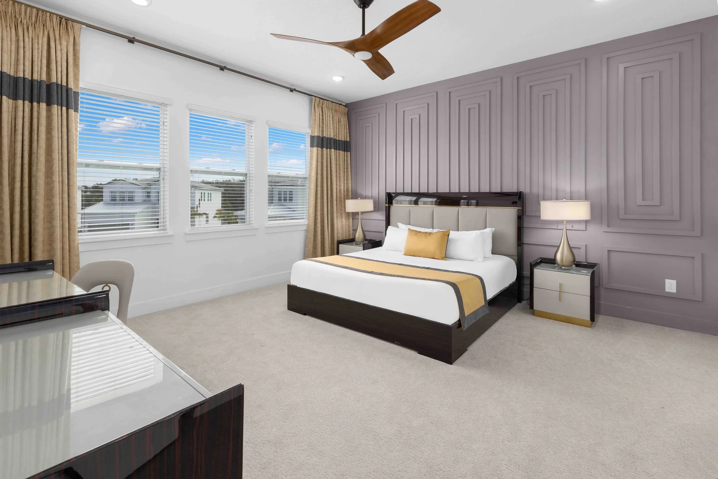 Primary bedroom with paneled wall and gold accents