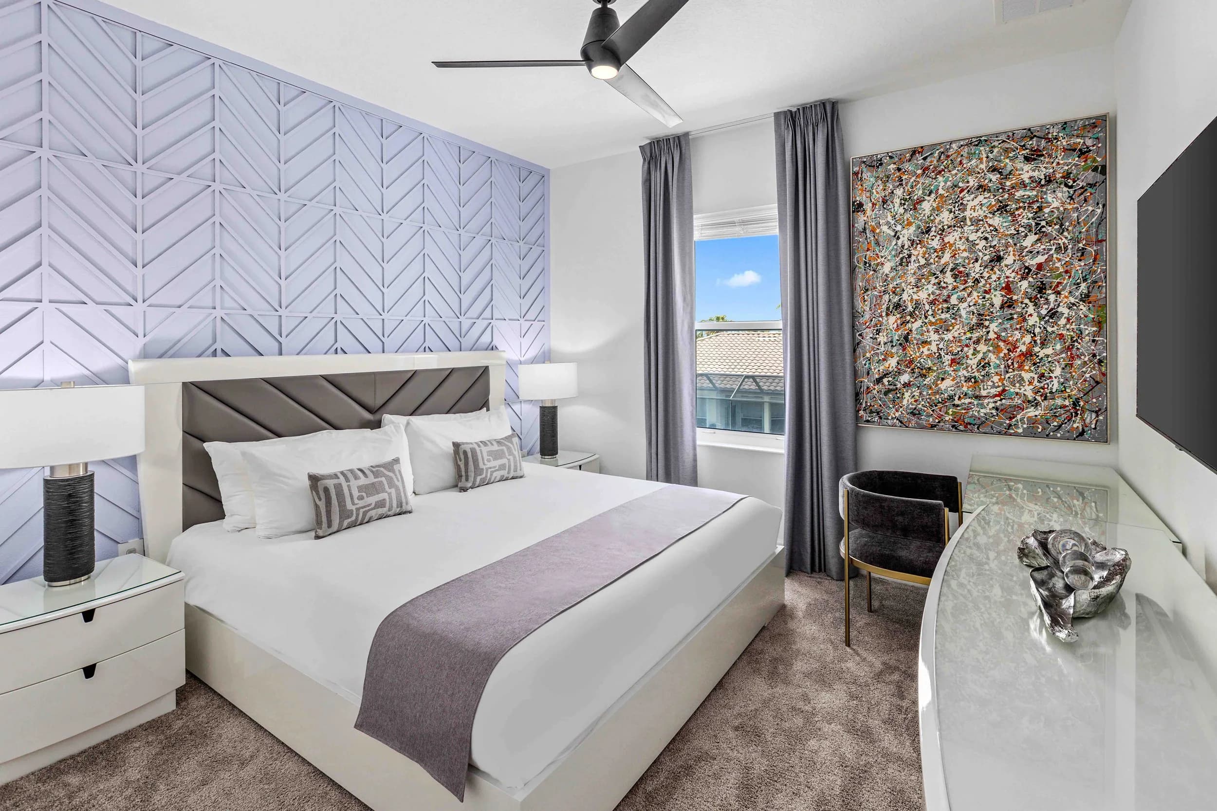 Bedroom with gray upholstered headboard and art wall