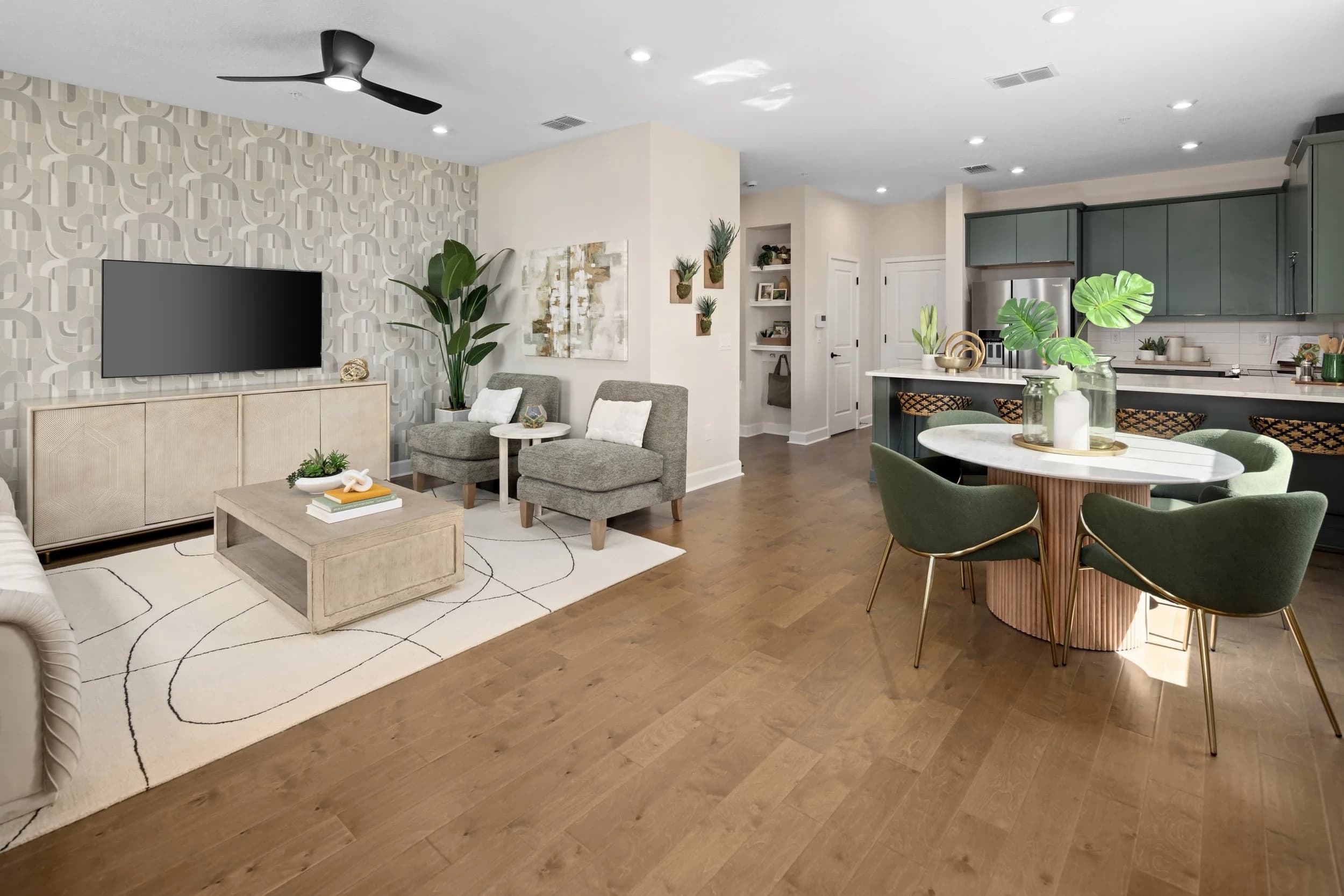 Open-plan great room with living area, round dining table and green kitchen