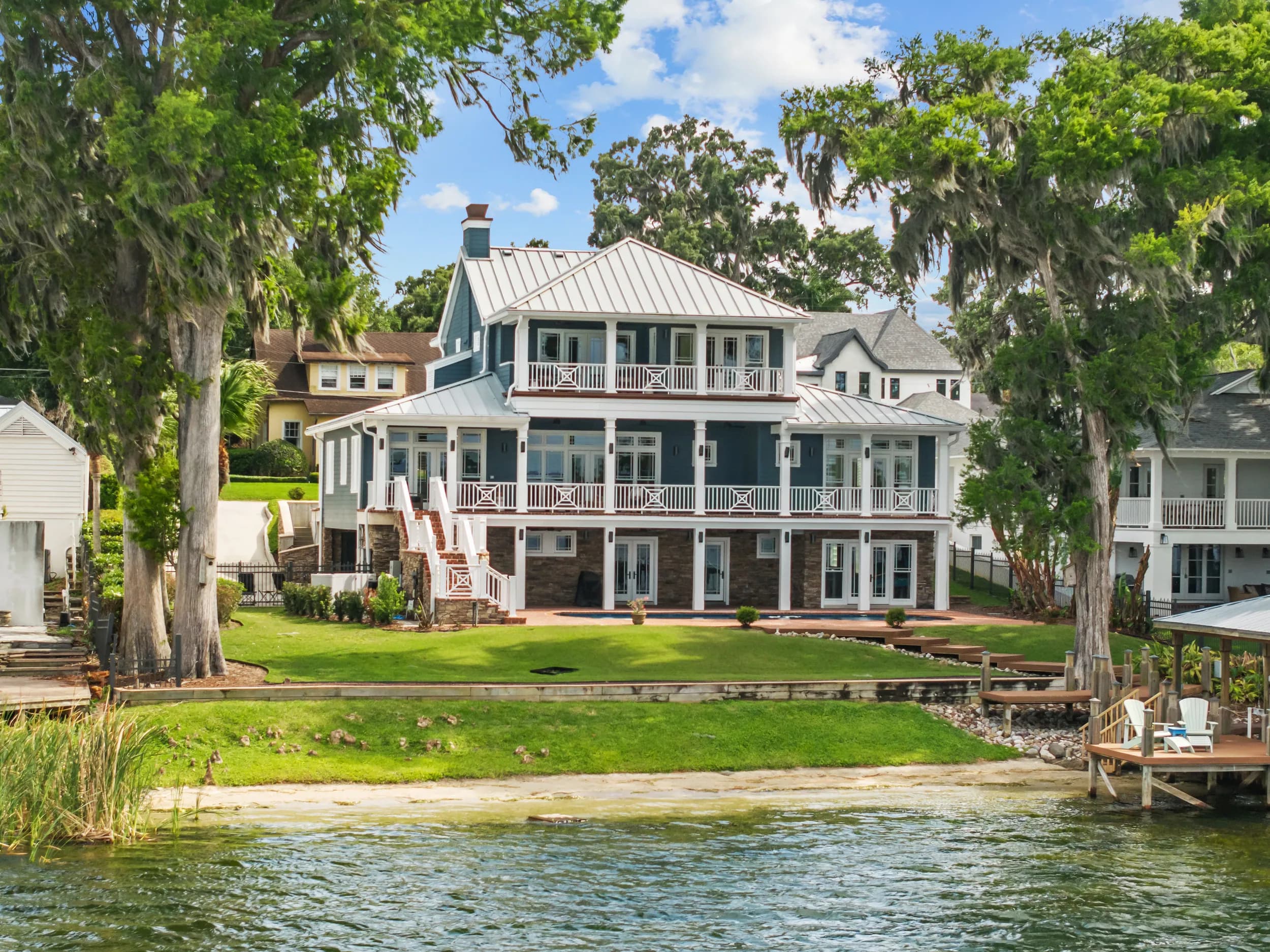 Three-story Lowcountry-style lakefront home with stacked porches, seen from the water