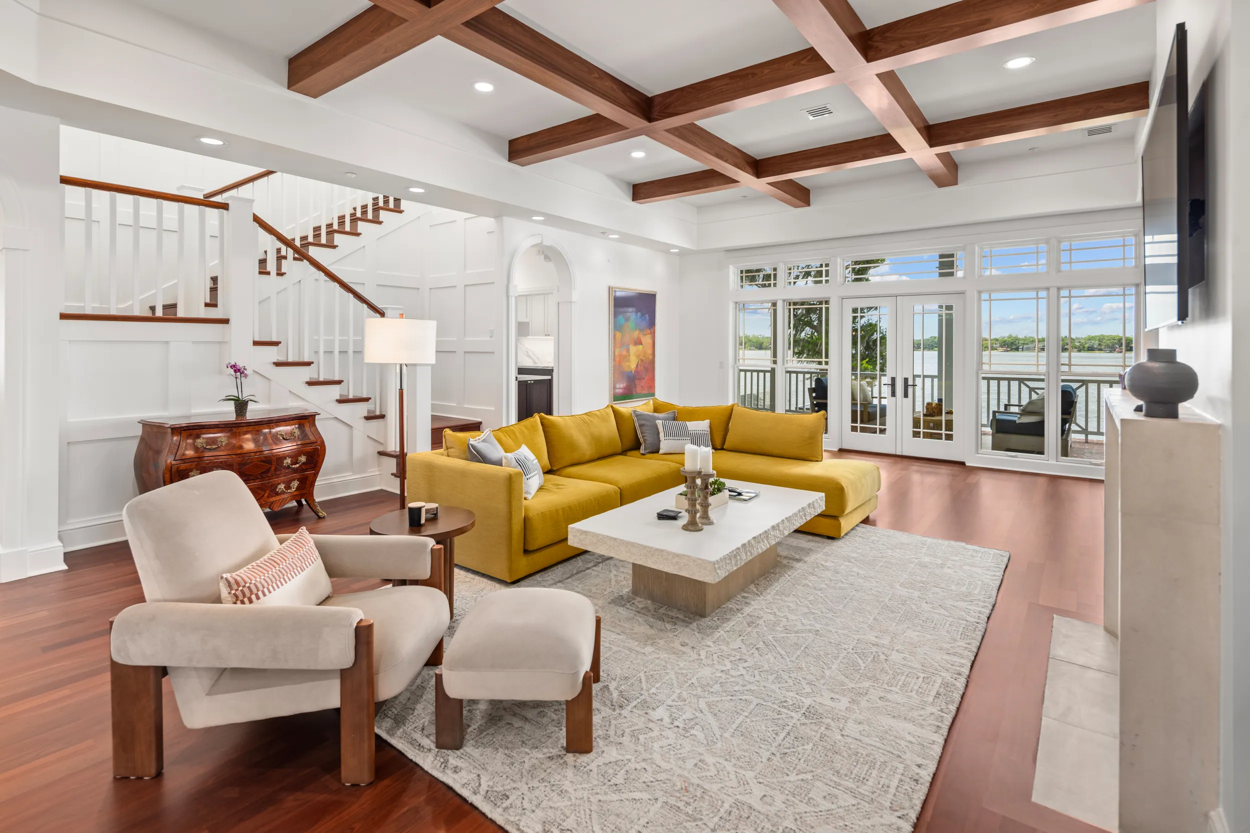 Living room with coffered ceiling, mustard sofa and the stair to the loft