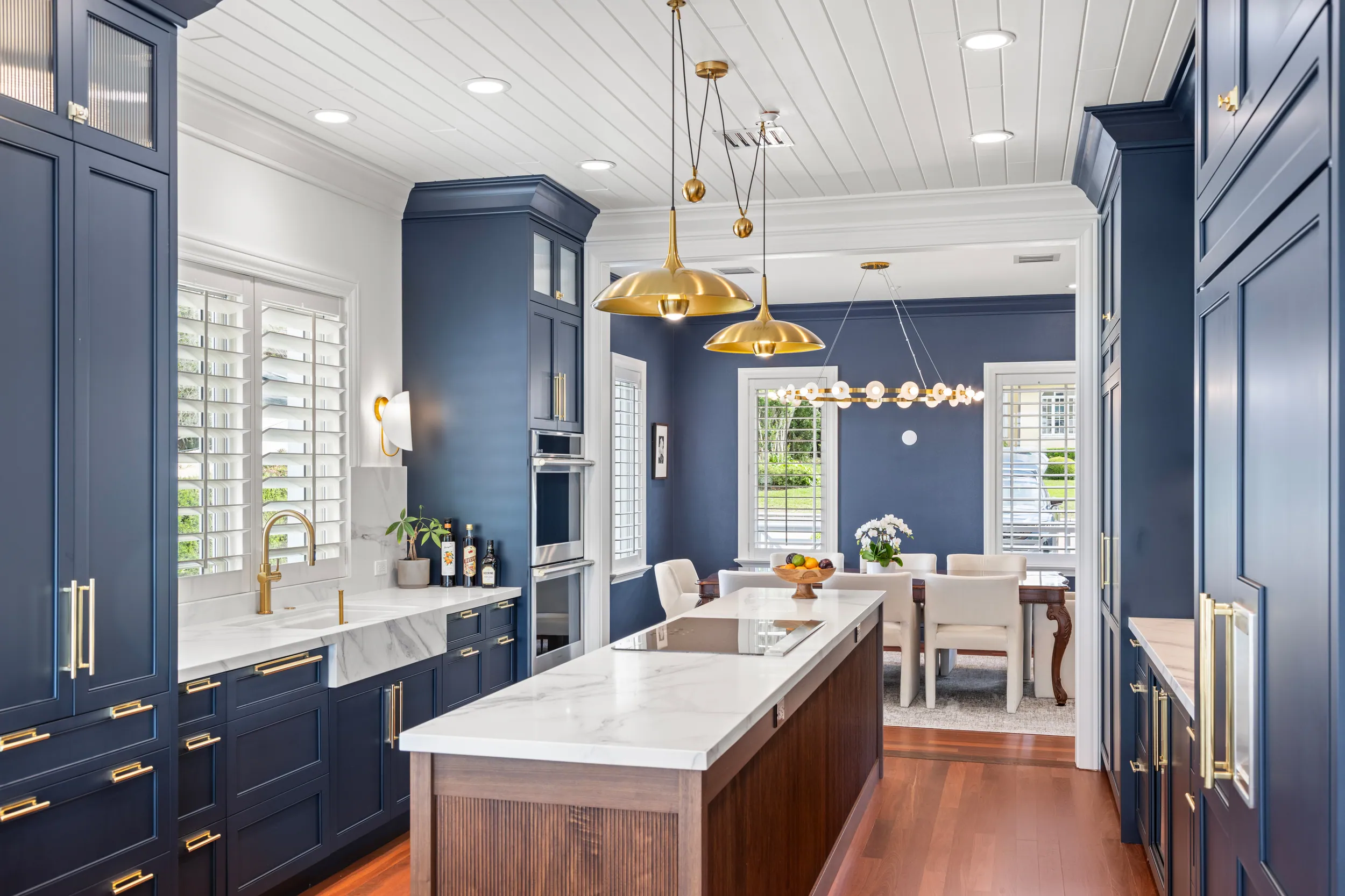 Navy kitchen with brass hardware, marble island and lake-facing windows