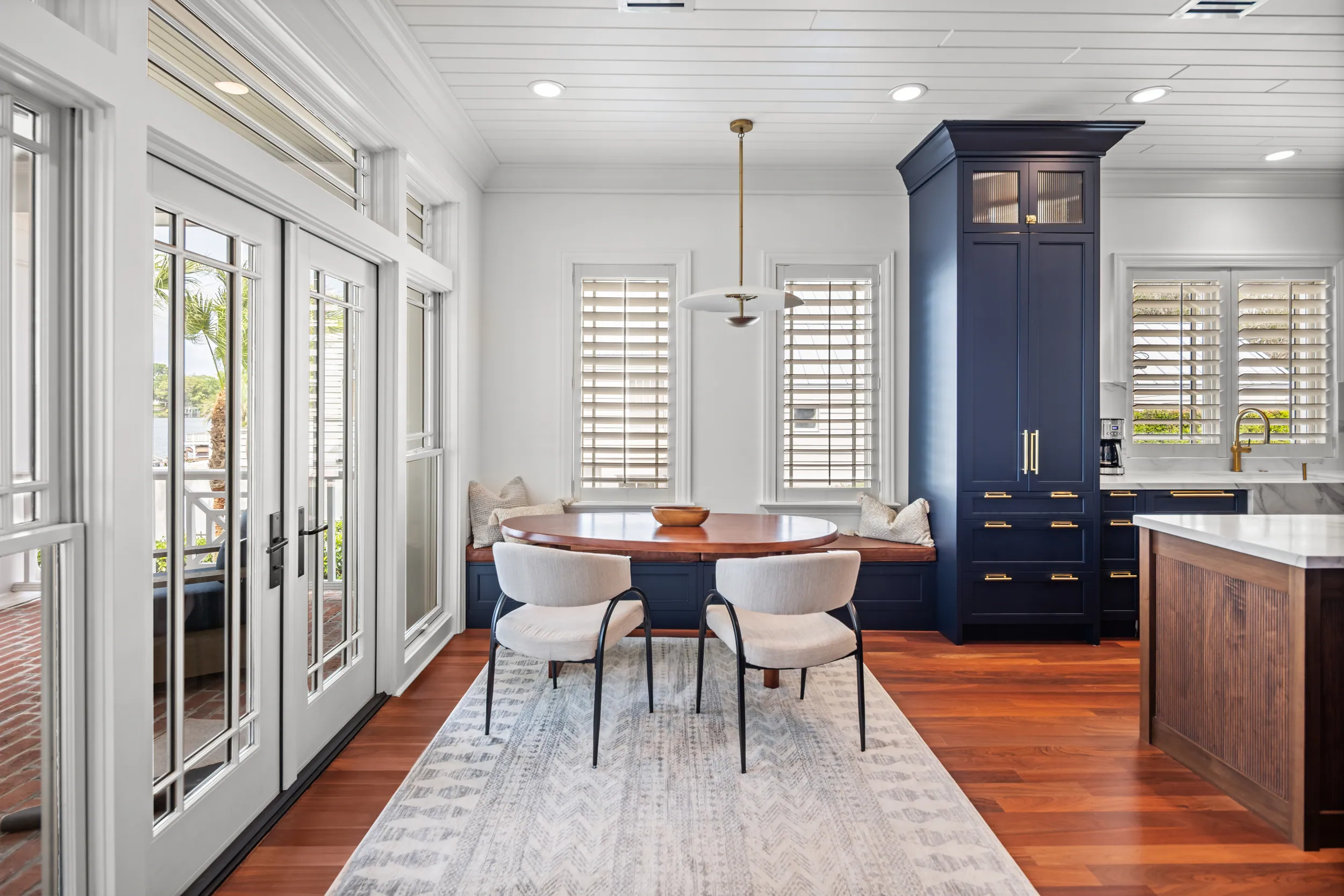Breakfast nook with plantation shutters and a navy built-in hutch