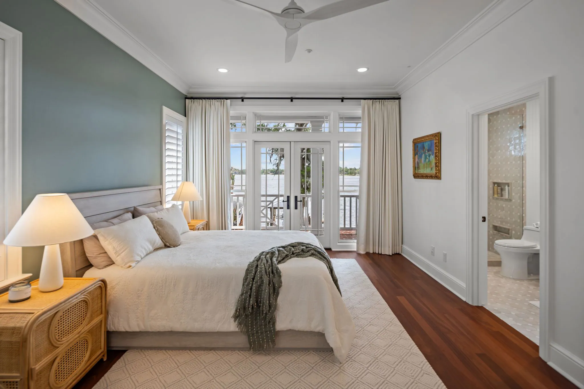 Guest bedroom with curtained doors opening onto the lake porch