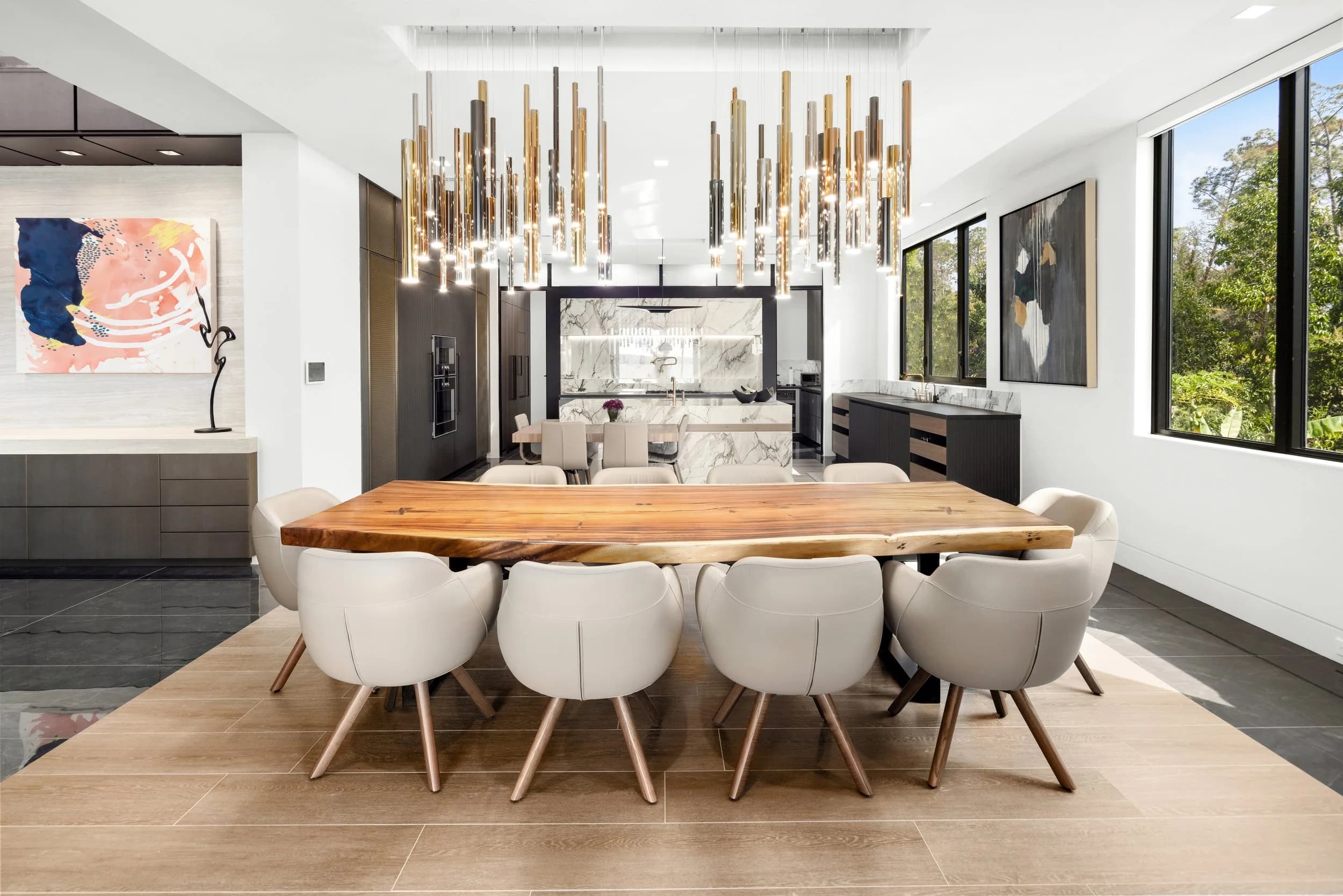 Dining room with live-edge wood table, cream chairs and a brass rod chandelier
