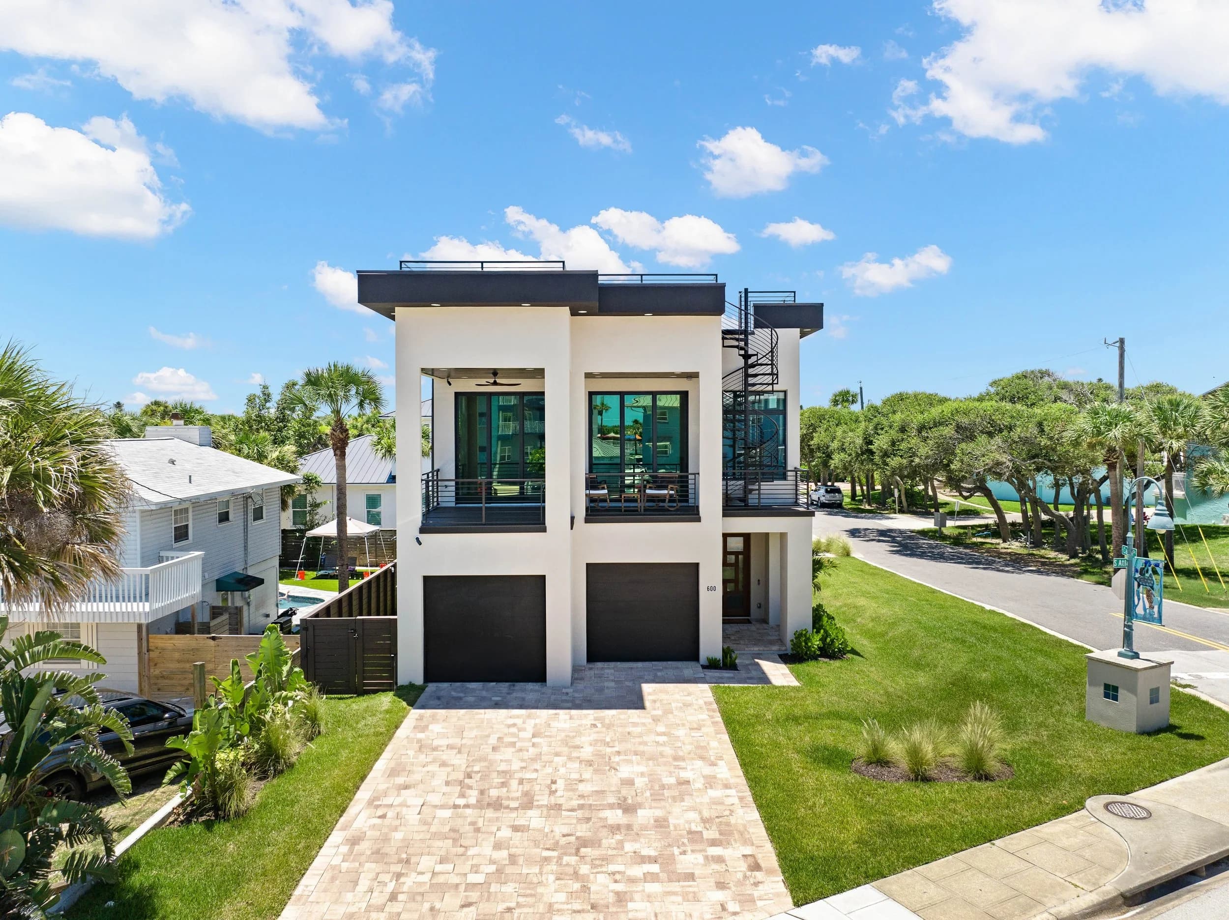 Modern two-story beach house front elevation with flat roof and glass rail, New Smyrna Beach