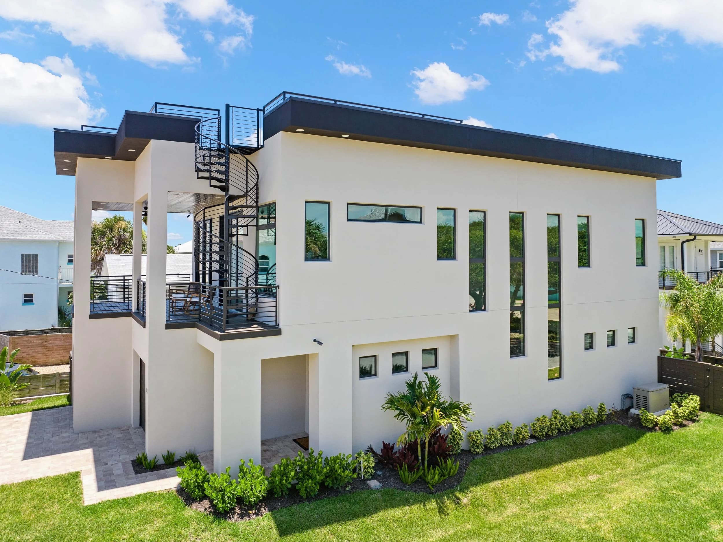 Side elevation by day with the exterior spiral stair, balcony and rooftop deck