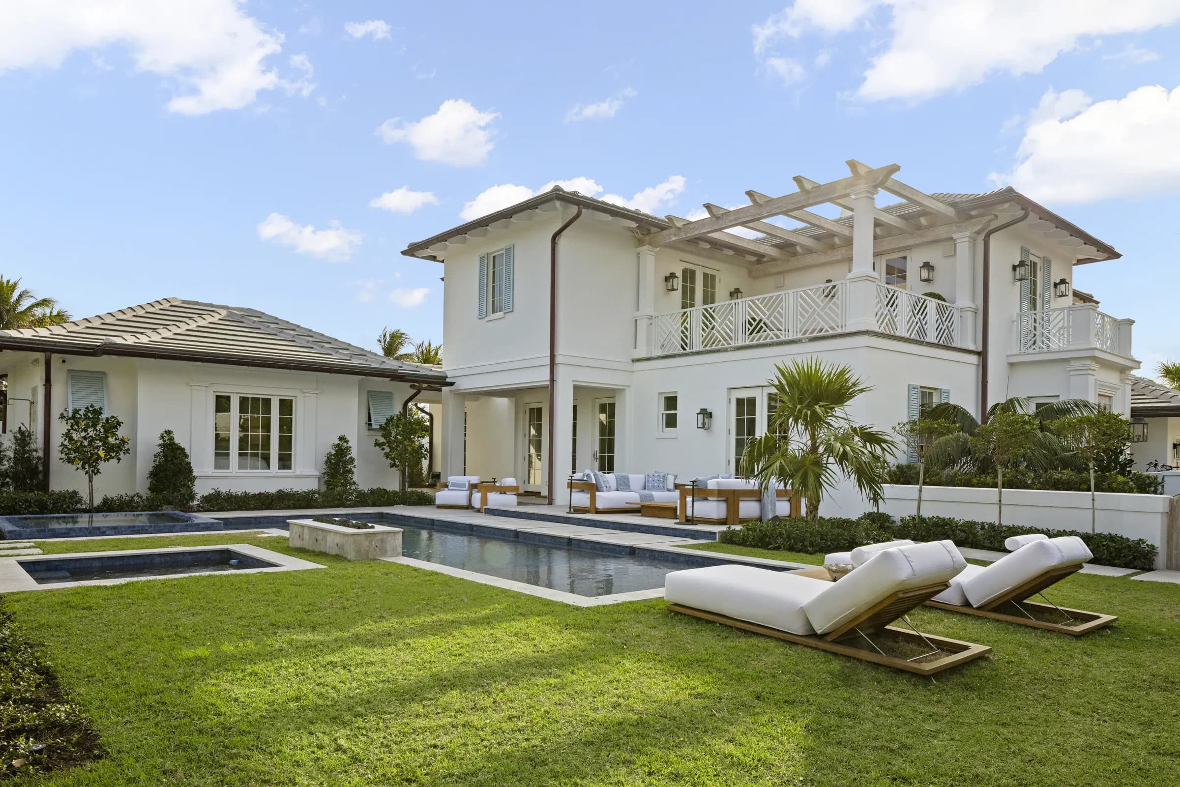 Rear lawn, pool and loungers in front of the two-story rear elevation