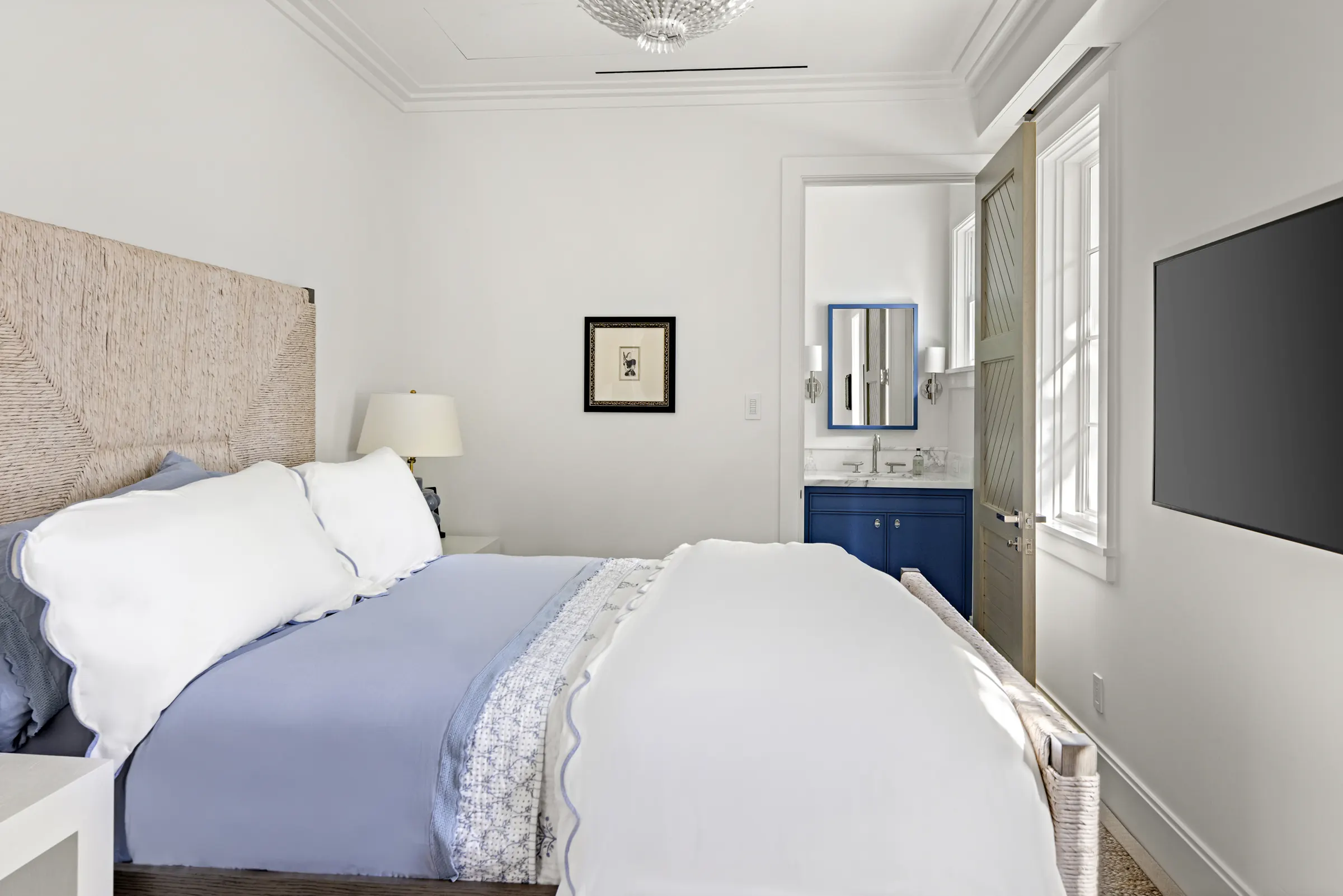 Guest bedroom with linen headboard and soft blue accents