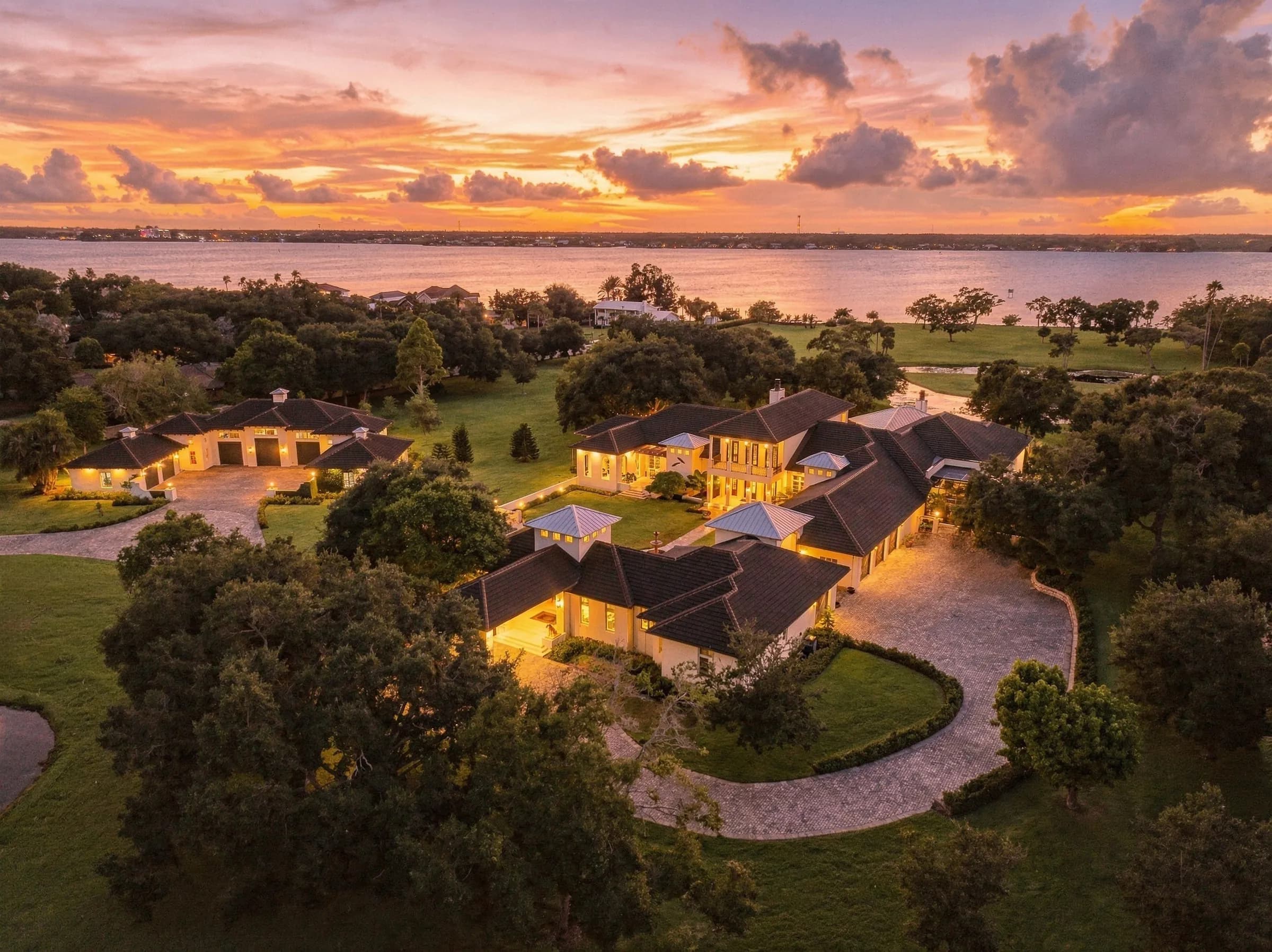 Golden-hour aerial of a lit estate on Merritt Island between the Indian River and the Banana River