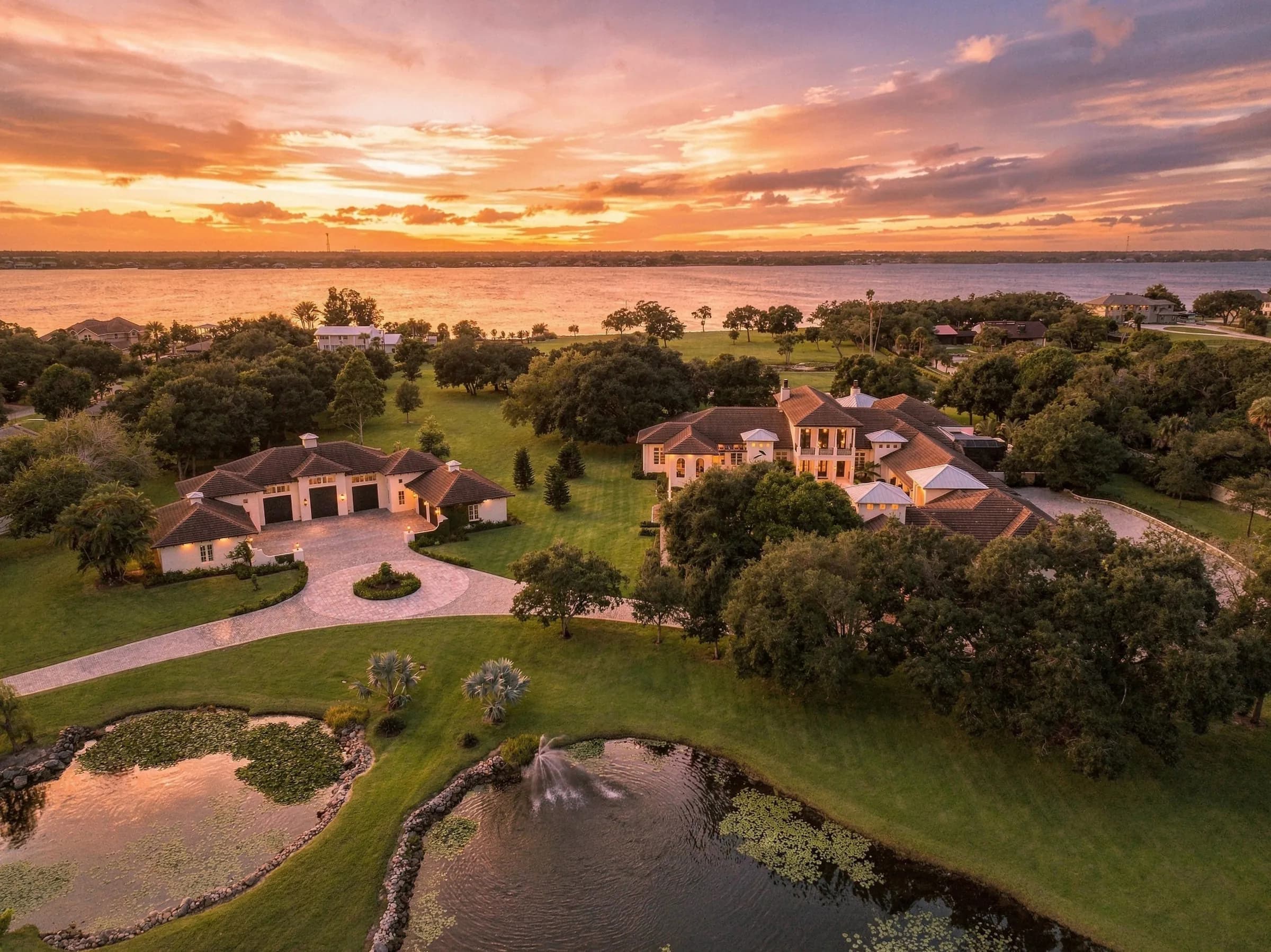 Golden-hour aerial over the lily ponds, the oaks and the river