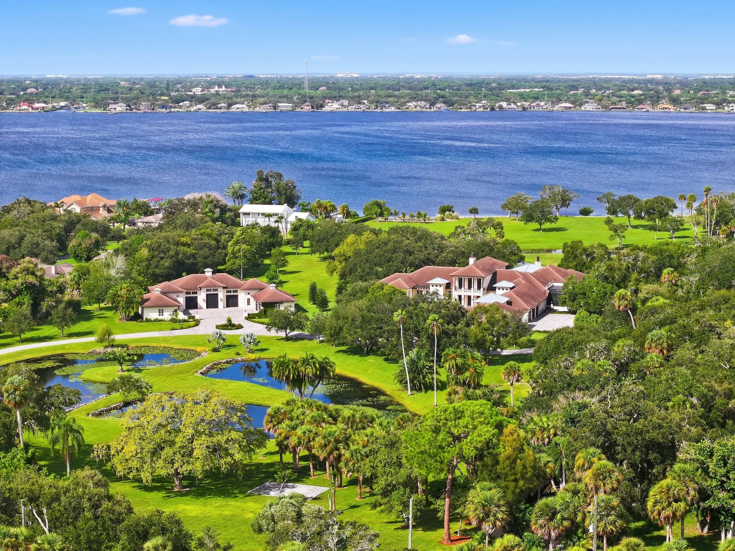Daytime aerial of the 16-acre estate with the river and the far shore beyond