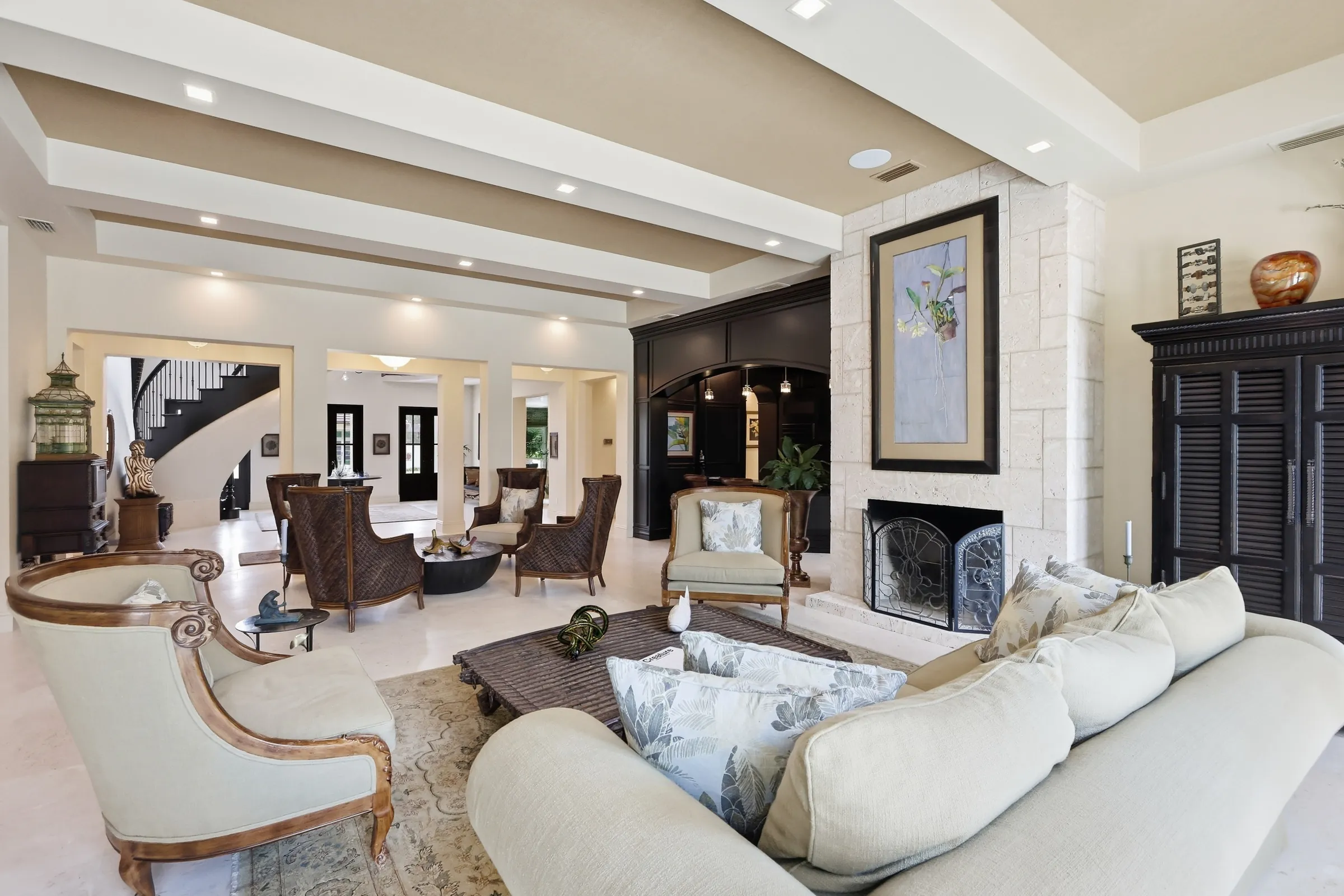 Great room with coral stone fireplace and the curved stair beyond