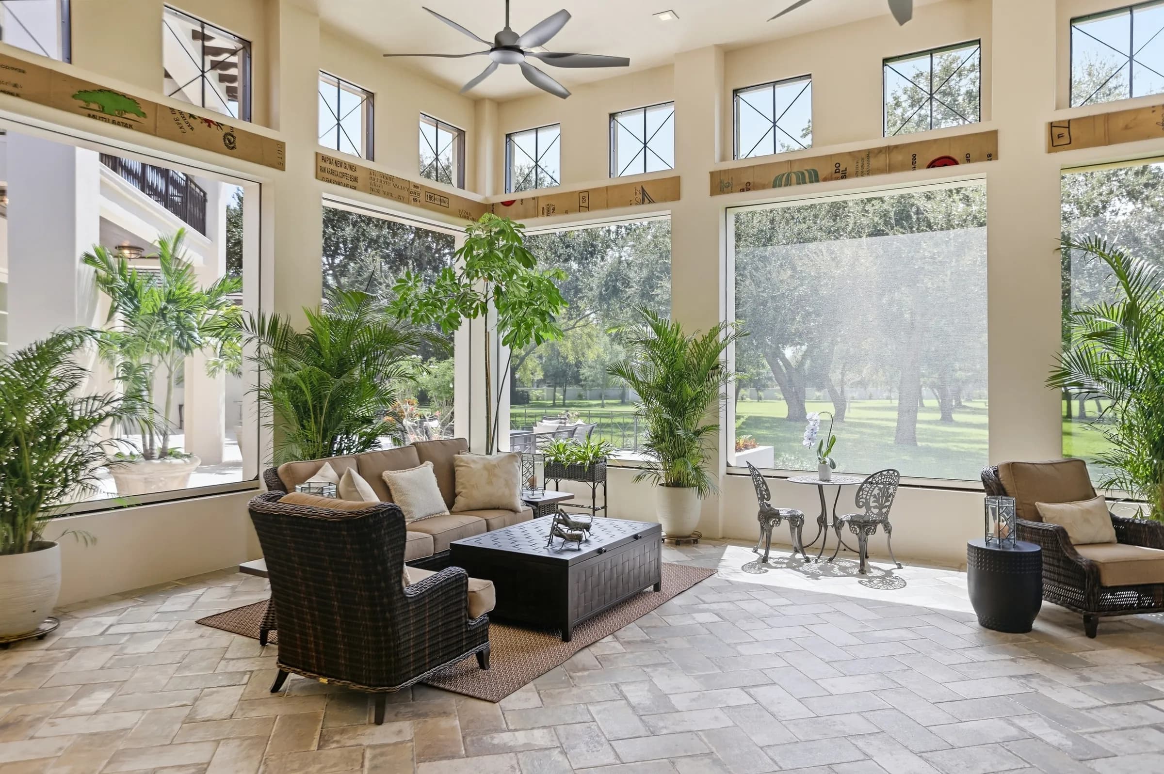Sunroom with tall windows over the lawn and canopy oaks
