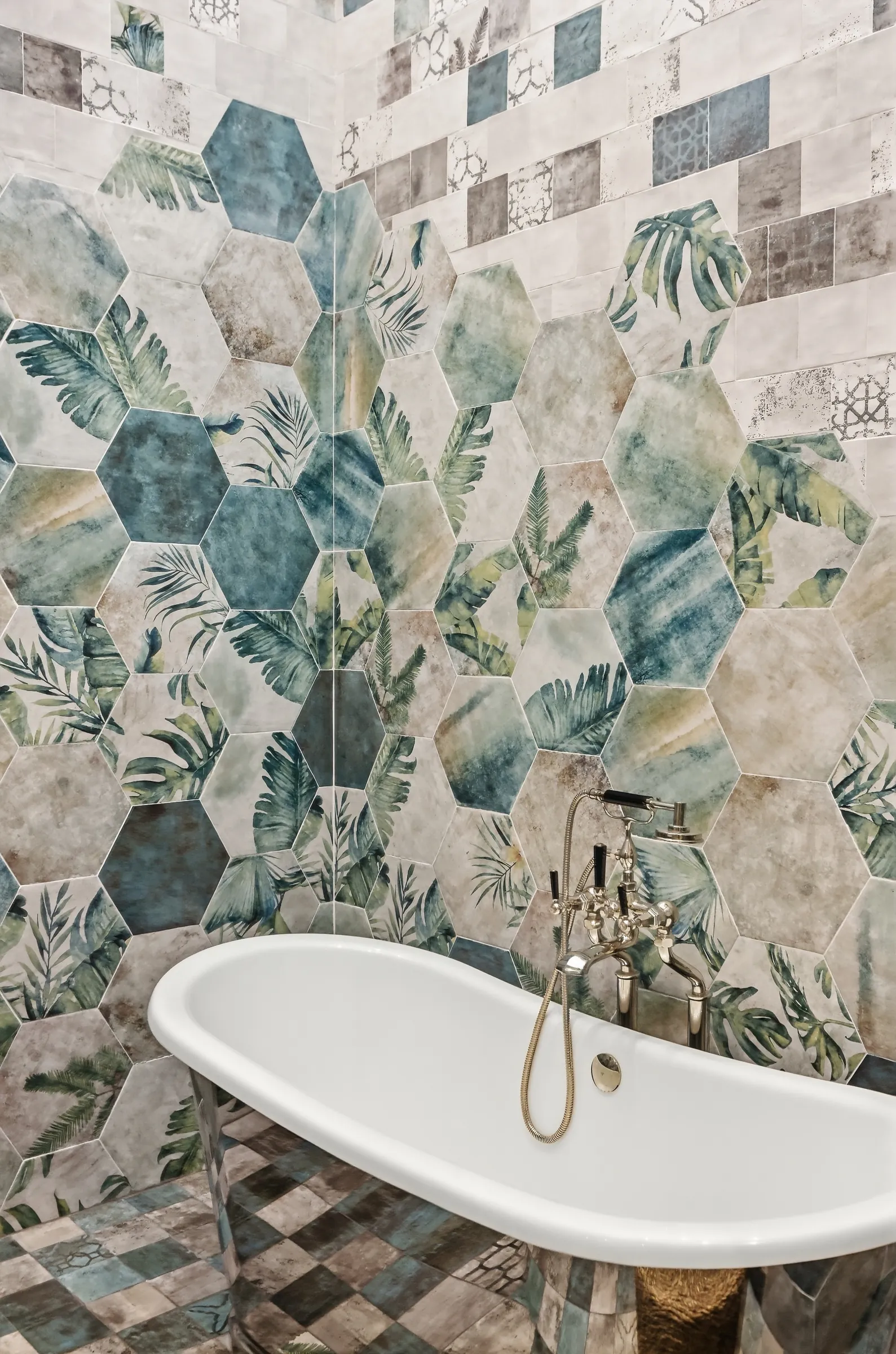 Freestanding tub against a wall of hand-made patterned tile