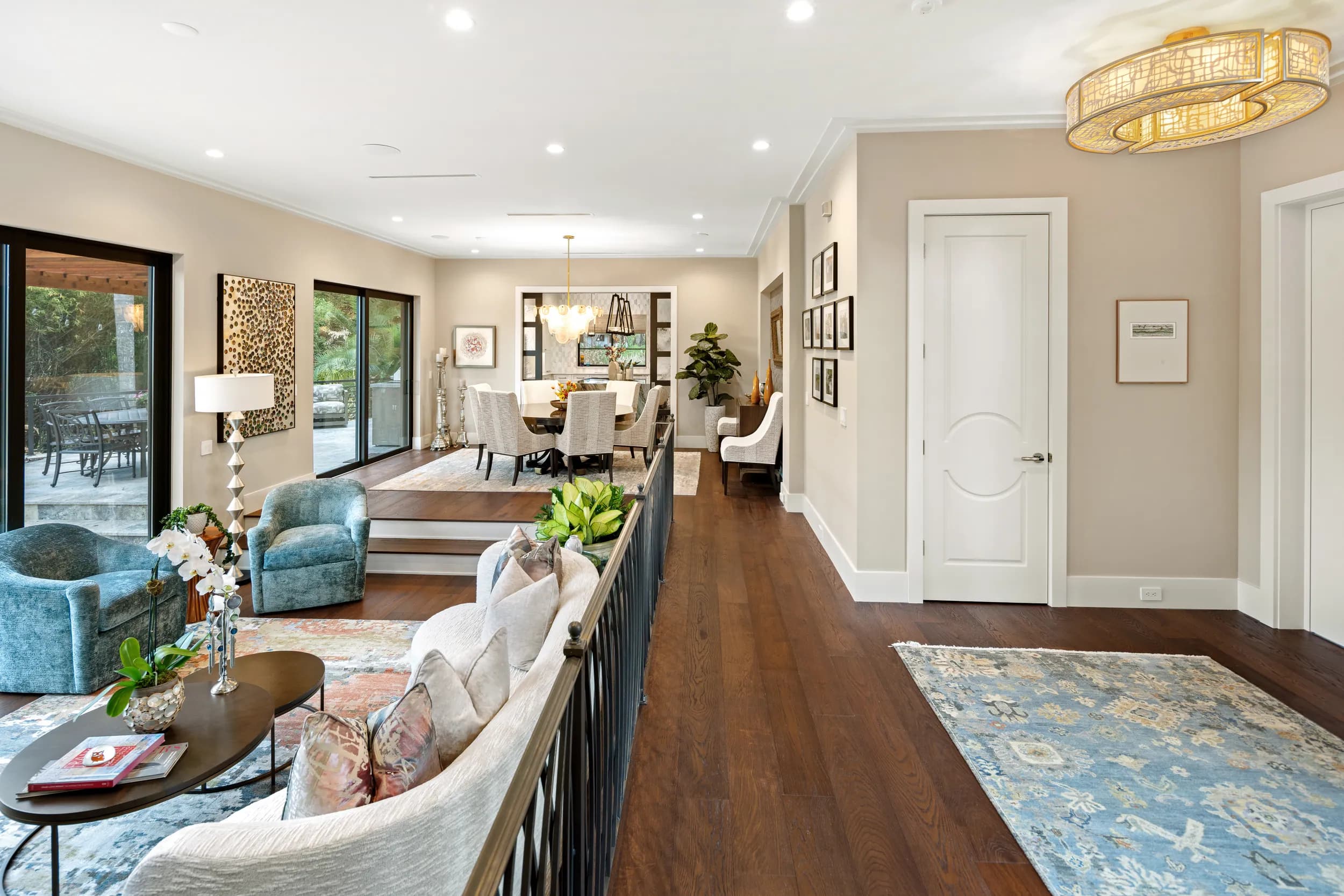 Great room looking through to the entry, iron railing and gold chandelier