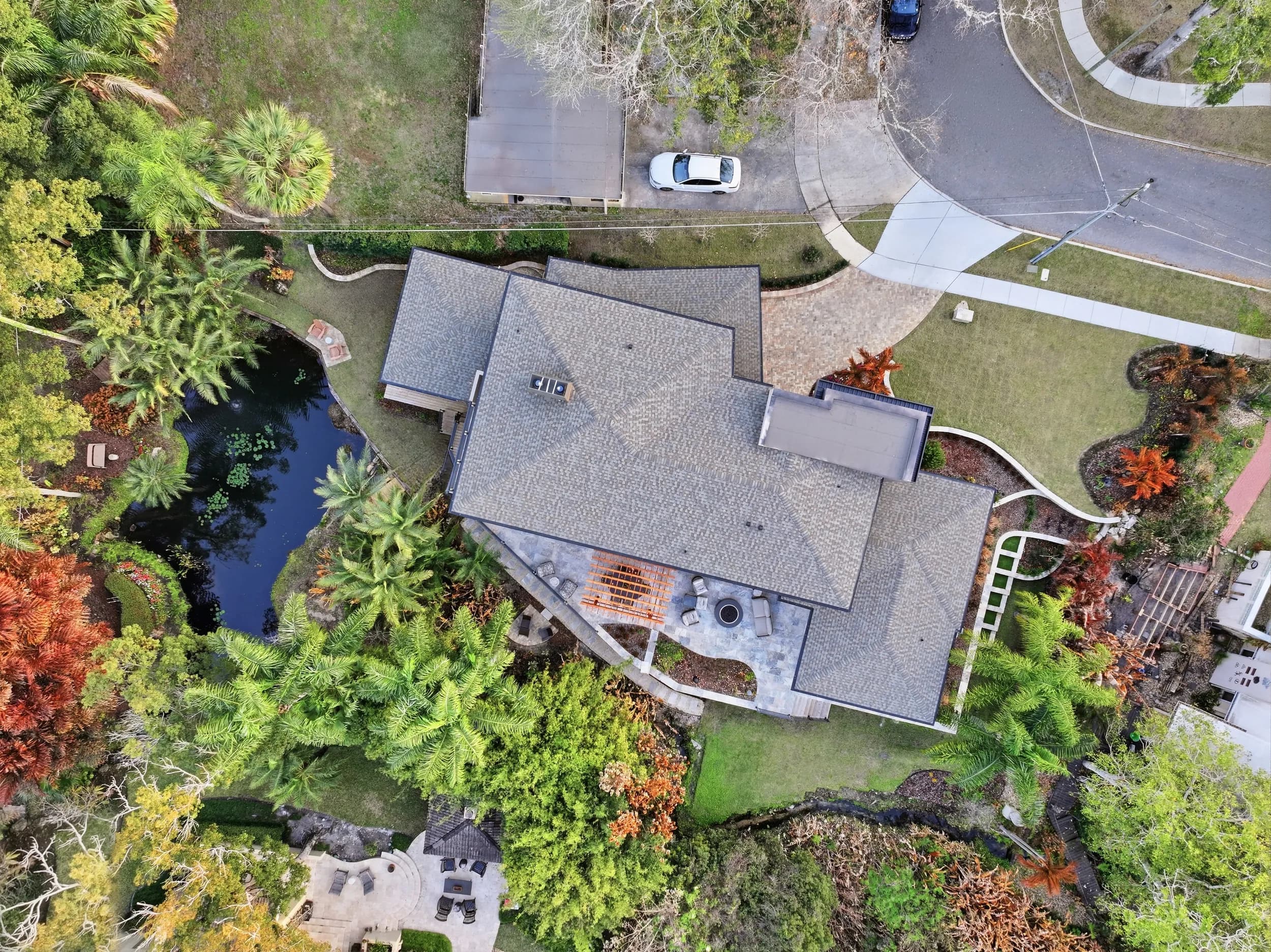 Top-down aerial of the roofline, pool and spring-fed pond